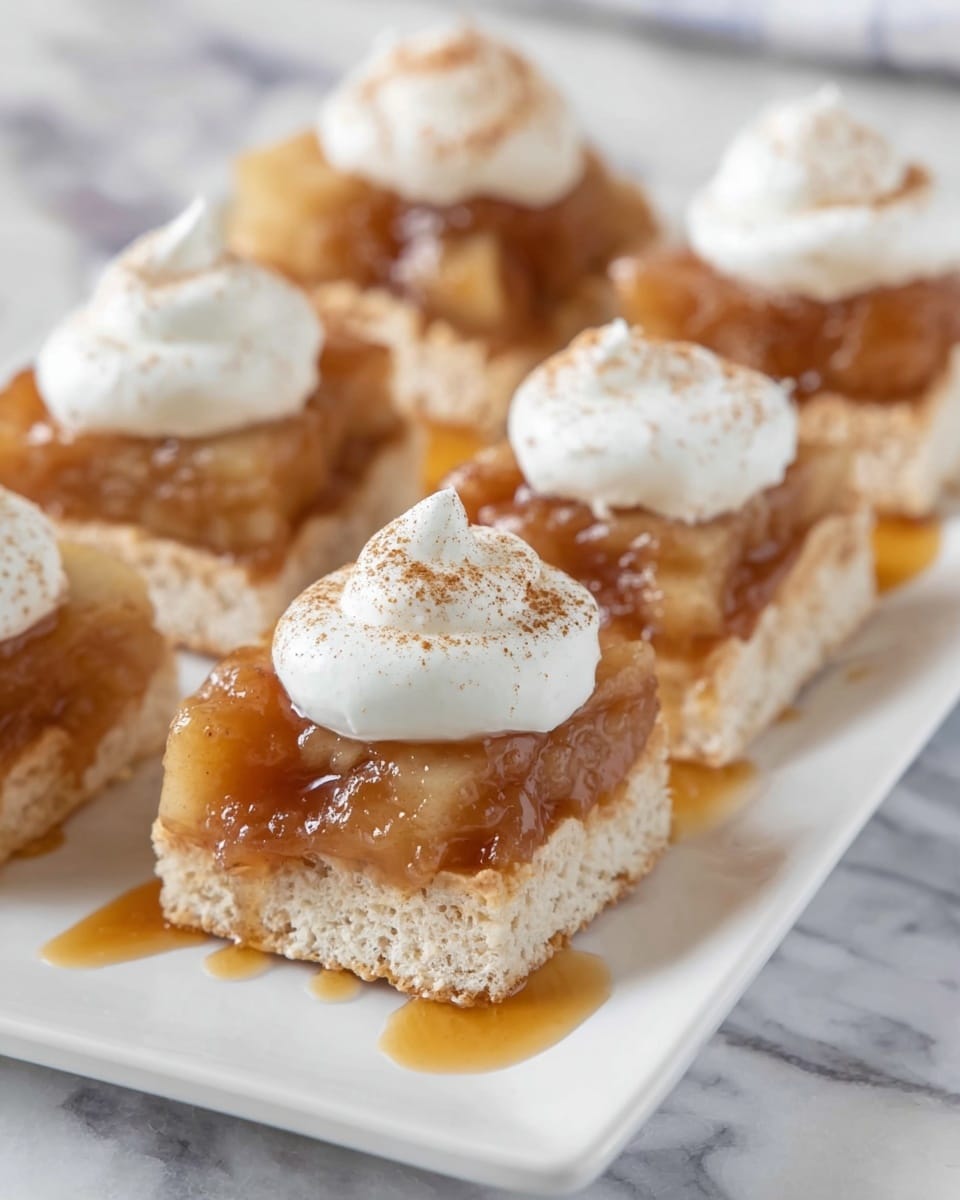 A close-up of a square rice crispy treat as the base, light beige and textured, topped with a thick shiny layer of smooth, golden caramel sauce covering the treat's surface and dripping slightly off the edges; on top of the caramel sits a rounded dollop of white whipped cream with a soft, fluffy texture, drizzled with more caramel sauce and lightly dusted with cinnamon powder. The treat rests on crinkled brown parchment paper placed on a wooden surface. In the background, several similar treats are visible, slightly out of focus, arranged on a white marbled surface. photo taken with an iphone --ar 4:5 --v 7