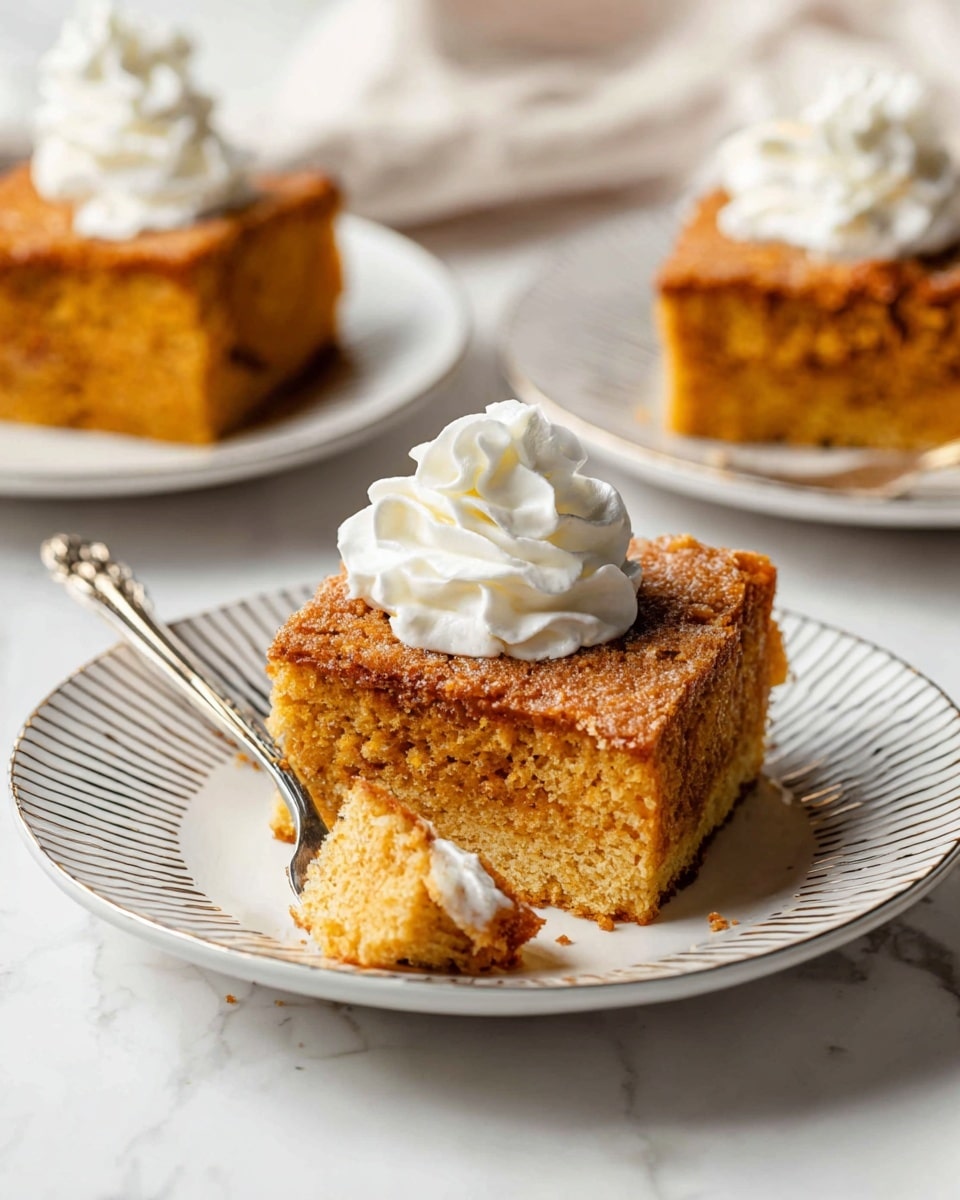 A square piece of golden brown cake with a textured top layer sits on a white plate with silver stripes, topped with a swirl of white whipped cream. The cake has two visible layers: a lighter, moist bottom layer and a darker, denser top layer. A fork holds a bite-sized piece of the cake close to the plate’s edge, showing the soft crumb inside. In the background, there are two more plates with similar cake slices, all placed on a white marbled surface. Photo taken with an iphone --ar 4:5 --v 7
