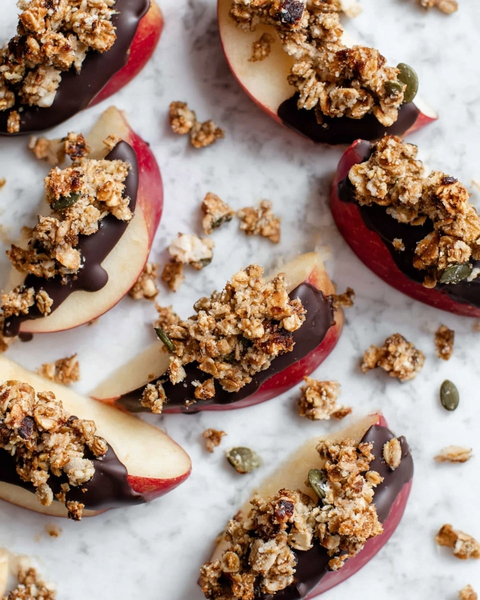 The image shows several apple slices arranged on crumpled white paper placed on a white marbled surface. Each apple slice has three layers: the base is a pale cream apple slice with red skin on the edge, the middle layer is a dark chocolate coating partially covering the apple, and the top layer is a rough, chunky granola mix with light brown oats and some pumpkin seeds scattered over the chocolate. Some granola crumbs are scattered around the slices. photo taken with an iphone --ar 4:5 --v 7