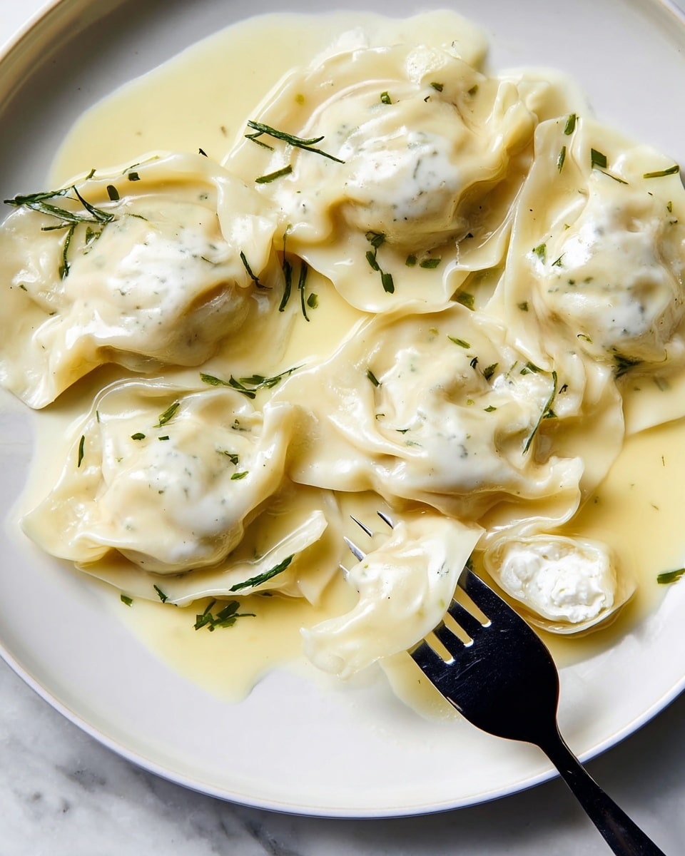 A white round plate holds six light beige tortellini filled with white cheese, arranged loosely with some overlapping. Each tortellini has a soft, smooth texture with gentle folds and slightly translucent edges. They sit in a creamy, pale yellow sauce that pools thinly around them, creating a smooth glossy base. Small green herb pieces are scattered over the tortellini and sauce, adding contrast. A black fork on the lower right lifts one tortellini showing its white cheese filling inside. The plate is placed on a white marbled surface. Photo taken with an iphone --ar 4:5 --v 7