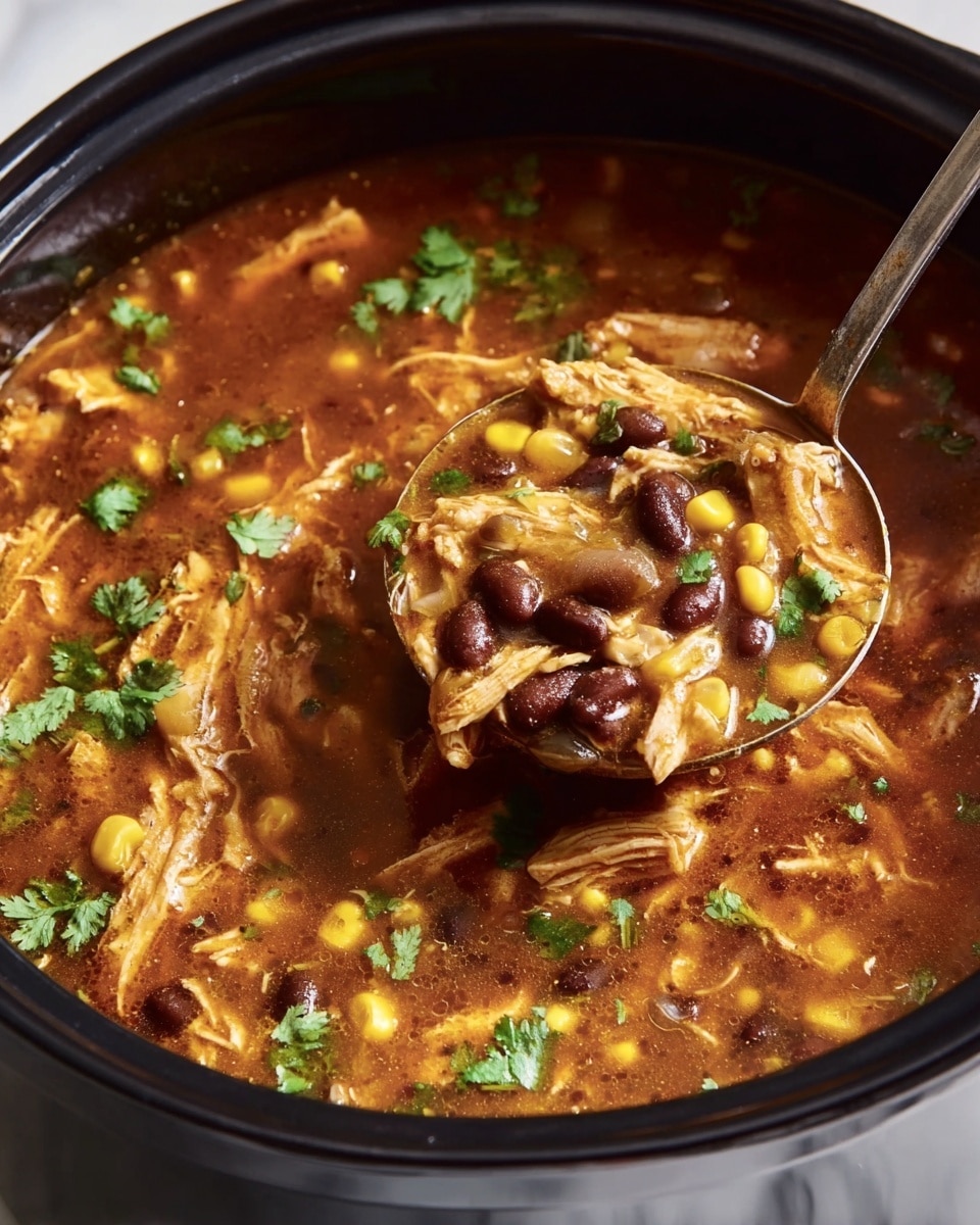 A close-up view of a black pot filled with a thick brown soup, showing three main layers: shredded light brown chicken pieces, whole black beans scattered evenly, and small yellow corn kernels mixed throughout. Fresh green cilantro leaves are sprinkled on top, adding bright color and texture. A metal ladle scoops a portion of the soup, lifting some beans and chicken above the pot. The scene is set on a white marbled surface. photo taken with an iphone --ar 4:5 --v 7