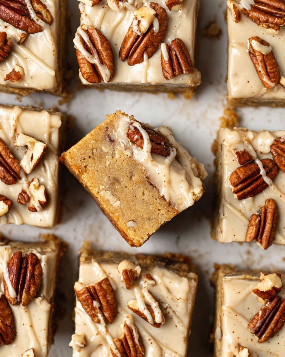 A stack of three square-shaped nut bars with a light brown color and visible pieces of nuts inside. The bars have a rough texture and are placed on a white marbled surface. A creamy light beige sauce is thickly drizzled over the top and sides of the stack, slowly dripping down. Small nut pieces are scattered around the base. The background is softly blurred with warm tones. photo taken with an iphone --ar 4:5 --v 7