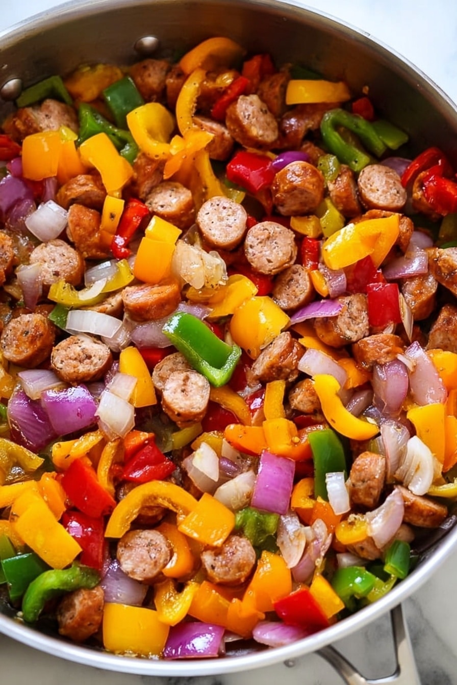 The image shows a pan filled with cooked sausage slices and mixed vegetables. There are three clear layers: the first layer is round sausage pieces that are browned and cooked, scattered evenly throughout the pan. The second layer consists of diced bell peppers in three colors—yellow, red, and green—each piece vibrant and slightly softened from cooking. The third layer includes chopped onions that are translucent with hints of light purple and white, mixed closely with the peppers and sausage. The pan itself is shiny metal on a white marbled texture surface. photo taken with an iphone --ar 2:3 --v 7 - Lightning-Fast Cheesy Three-Pepper Ravioli with Italian Sausage, quick Italian sausage pasta, easy cheesy pepper ravioli, speedy pepper and sausage dinner, flavorful 20-minute pasta