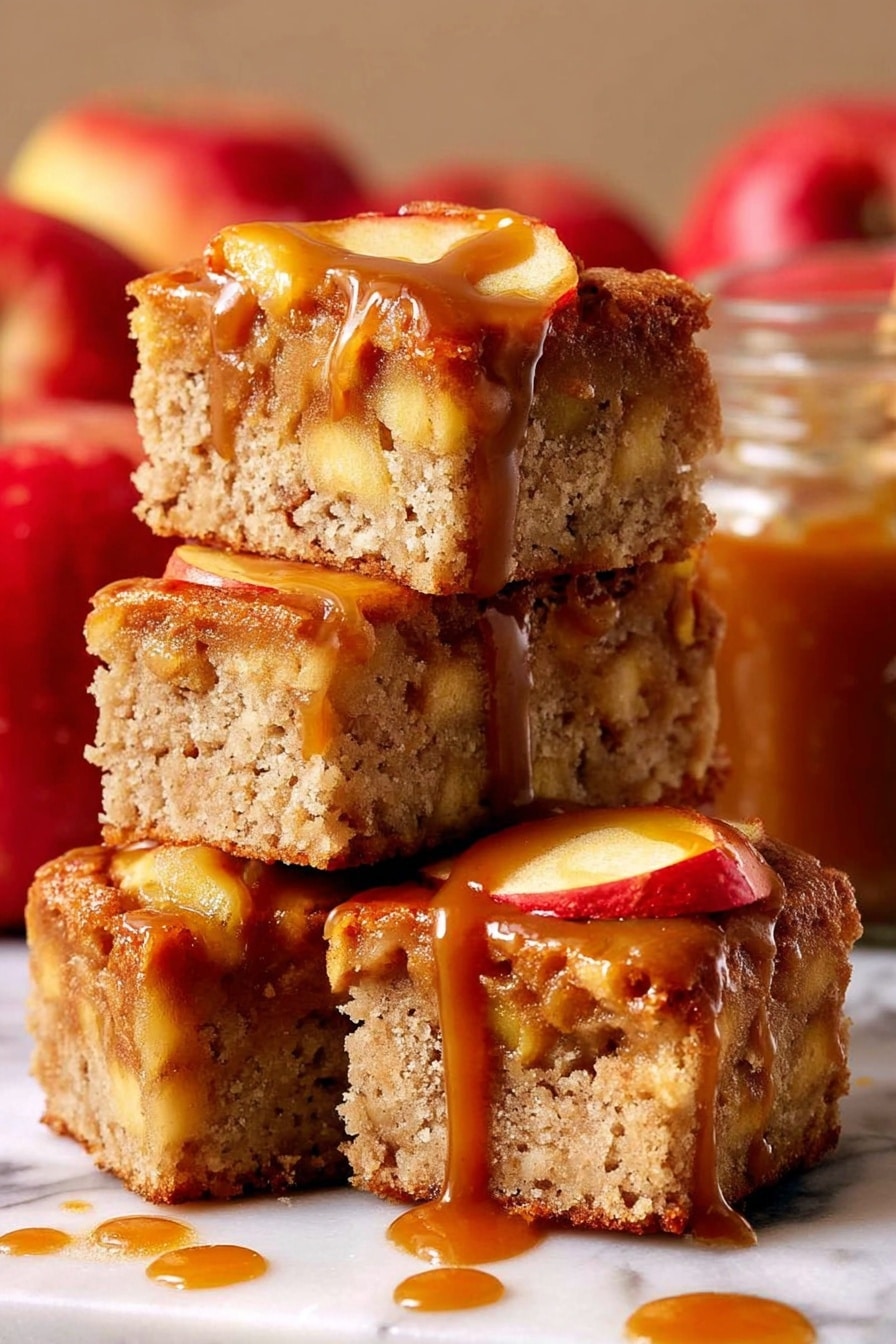 The image shows four thick square pieces of apple cake stacked on each other on a white marbled surface. Each piece has a light brown, porous texture with visible chunks of apple inside and apple slices on top. The top layer is covered in a shiny, caramel brown sauce that drips down the sides of the cake pieces. In the background, there are red apples and a glass jar filled with caramel sauce, slightly blurred. The lighting highlights the moist texture of the cake and the glossy caramel sauce photo taken with an iphone --ar 2:3 --v 7 - Caramel Apple Cake, caramel apple cake recipe, apple cake with caramel, fall apple cake, easy apple cake recipe