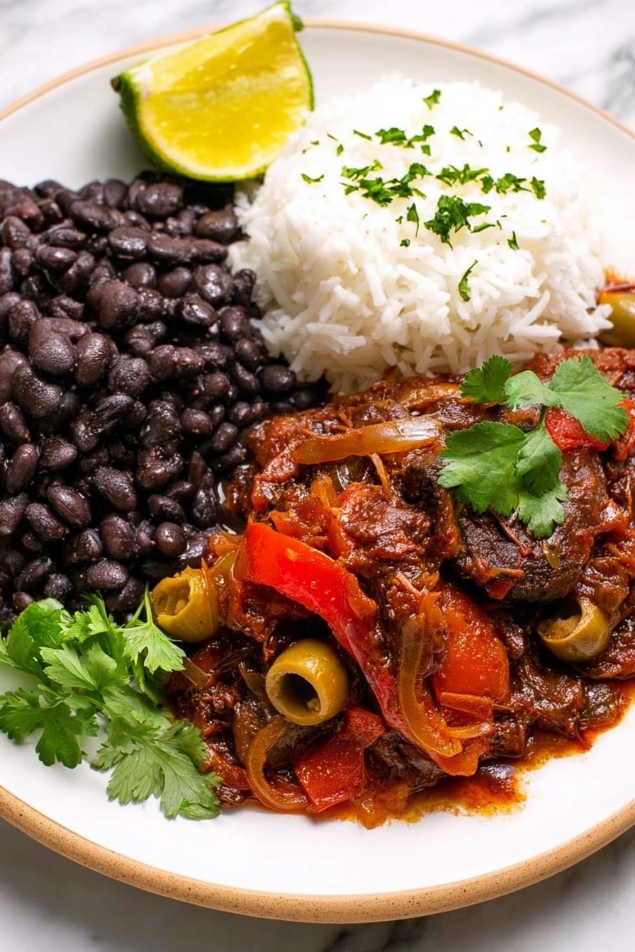 A white plate holds three main layers of food on a white marbled surface. On the left side is a thick layer of black beans with a slightly soft texture made from many whole beans. Next to the beans, on the right side of the plate, is a mound of fluffy white rice with a light, grainy texture. In the front and center, there is a layer of rich, dark red stew with visible pieces of green olives and slices of red bell pepper, covered in a thick, sauce with a chunky texture. A bright yellow lemon wedge rests on the left side of the plate, and a small sprig of fresh green cilantro is placed on top of the stew, adding a touch of vibrant color. Photo taken with an iphone --ar 2:3 --v 7 - Slow Cooker Ropa Vieja, Cuban shredded beef stew, easy Cuban recipes, beef stew in slow cooker, authentic Cuban dishes