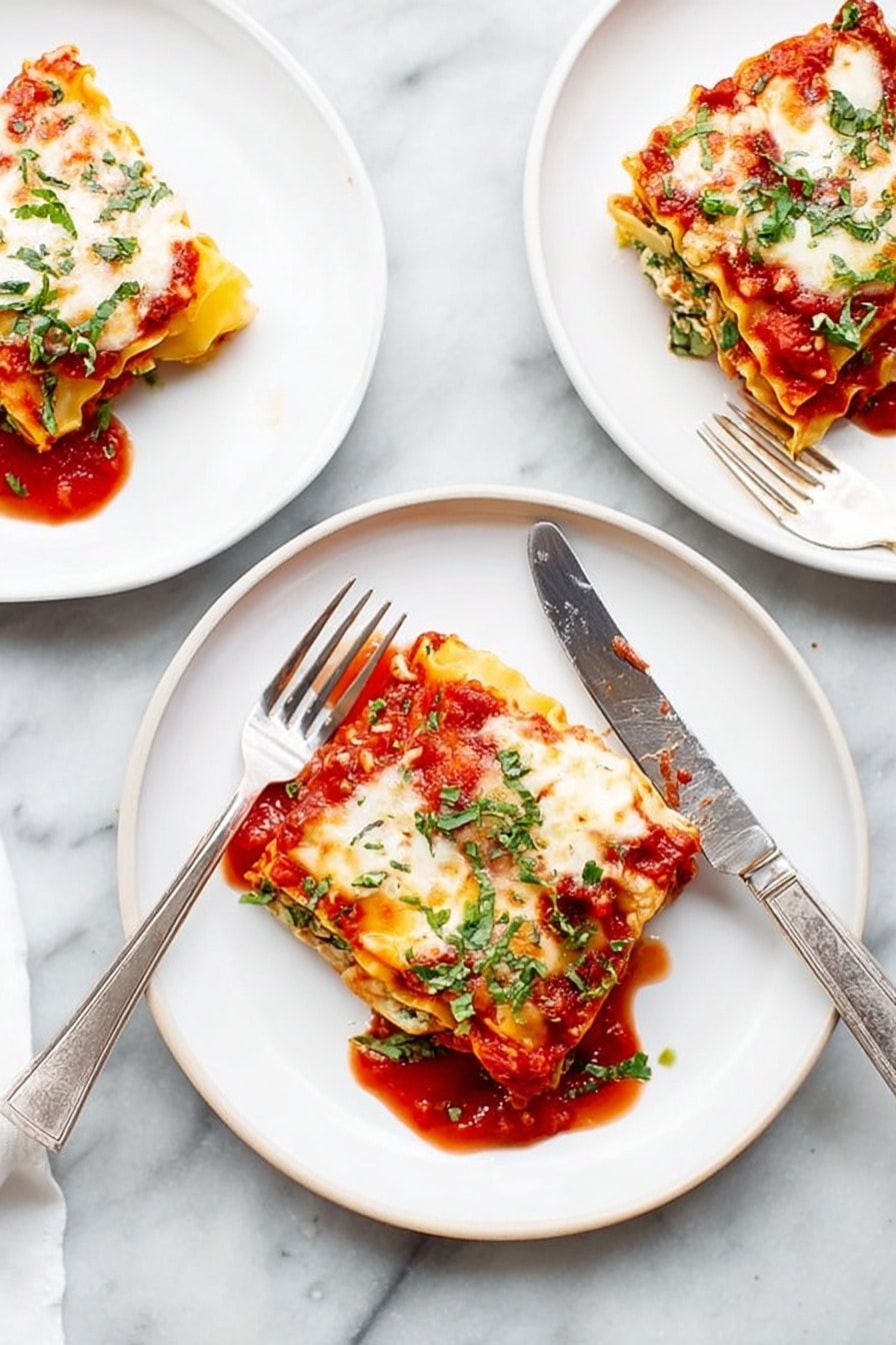 There are three white plates on a white marbled surface, each with a square piece of lasagna. Each lasagna piece has visible layers: a red tomato sauce at the bottom, a yellow pasta sheet, white cheese melted on top with some browned spots, and green herbs sprinkled over all. One plate in the middle has a fork and a knife resting on the edges, the knife laying diagonally across the plate. The tomato sauce slightly spreads around each lasagna piece, adding a bright red contrast to the white plates and light background. Photo taken with an iphone --ar 2:3 --v 7 - Spinach Lasagna Roll Ups, spinach lasagna roll ups recipe, easy spinach lasagna rolls, cheesy spinach lasagna, healthy lasagna roll ups