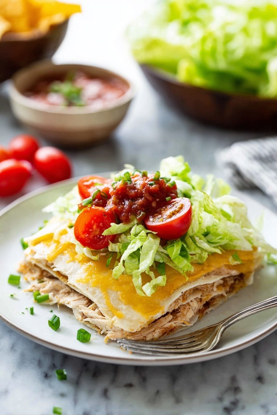A white plate holds a layered dish with four clear layers: the first layer is a soft tortilla in light beige, topped with shredded cooked chicken in light brown; the second layer is another tortilla; the third is melted golden-yellow cheese with a creamy texture; the fourth layer consists of fresh bright green lettuce, bright red halved cherry tomatoes, green sliced chives, and a small spoonful of chunky red salsa on top. A silver fork lies on the plate's edge. The background shows a white marbled surface with out-of-focus bowls of salsa, chips, and lettuce. Photo taken with an iphone --ar 2:3 --v 7 - Cheesy Chicken Quesadilla Casserole, cheesy chicken casserole, easy quesadilla bake, cheesy chicken dinner, quick chicken casserole