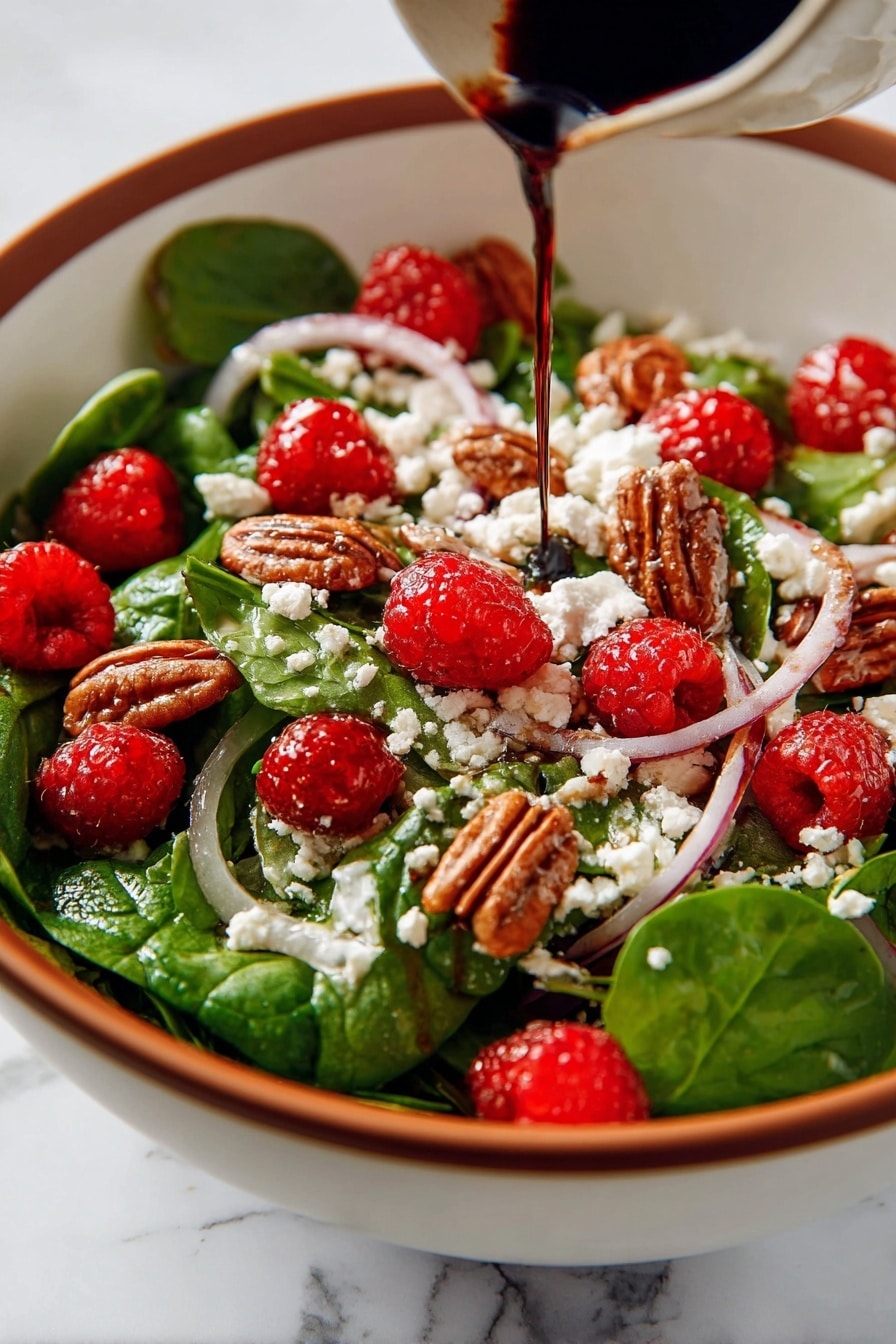 This image shows a fresh salad in a white bowl with a wooden spoon on the side. The salad has several layers and colors: the base is bright green spinach leaves mixed with thin slices of purple onion; scattered on top are red raspberries and brown pecan nuts adding texture; white crumbled goat cheese is spread evenly across the salad, with dark balsamic glaze drizzled over everything, giving a shiny and rich look. The bowl rests on a blue cloth, all placed on a white marbled surface. Photo taken with an iphone --ar 2:3 --v 7 - Mixed Spinach Salad with Goat Cheese, Raspberries, and Toasted Pecans, spinach salad with goat cheese and raspberries, healthy berry spinach salad, easy gourmet salads, fresh fruit and nut salads