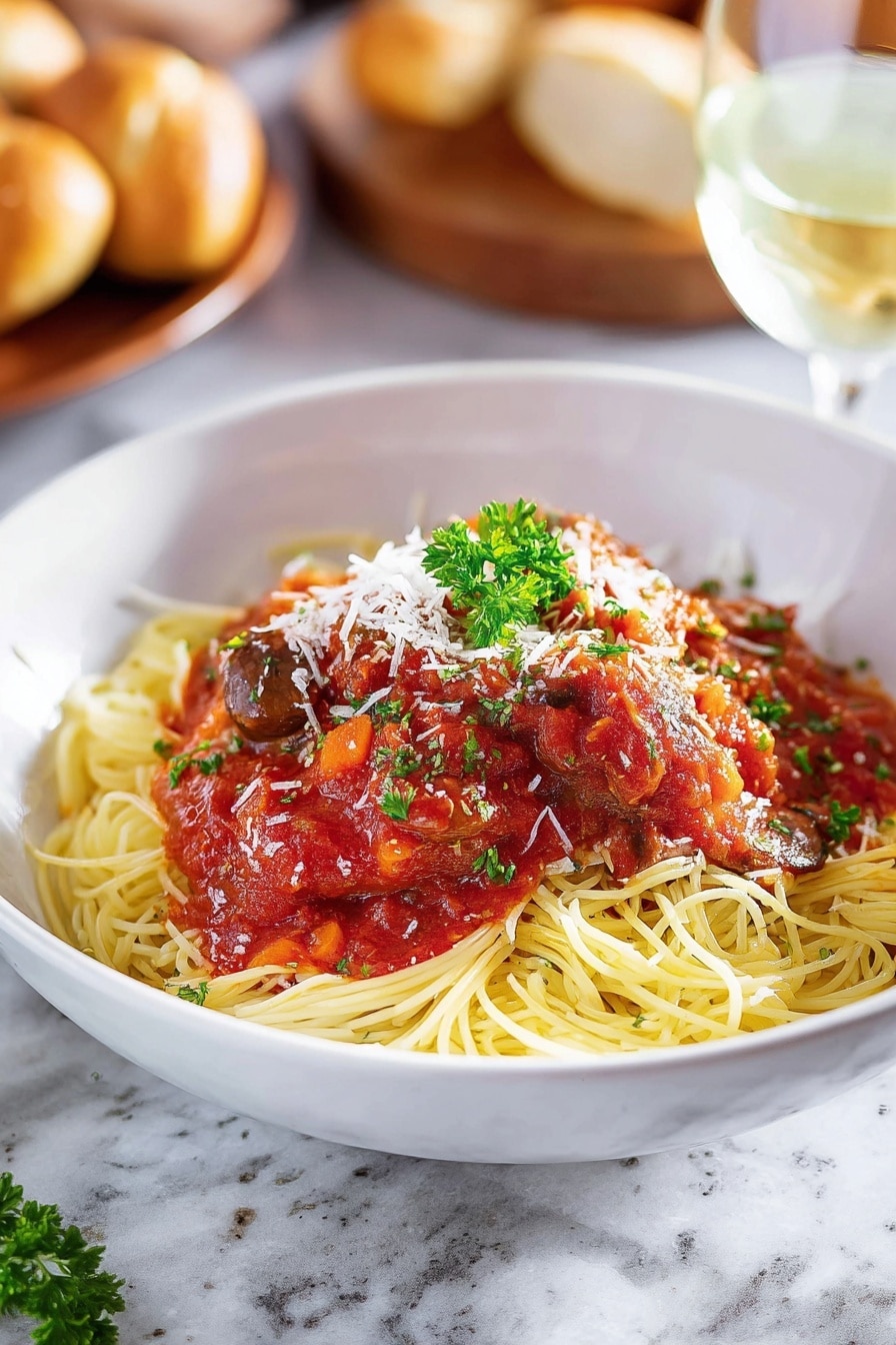 A white bowl filled with a bed of yellow spaghetti noodles forms the bottom layer, topped with red tomato sauce mixed with dark brown mushroom pieces and a piece of cooked white meat covered in sauce at the center. White shredded cheese is sprinkled lightly over the sauce and meat, and a small green parsley sprig sits on top for garnish. A golden brown breadstick lies diagonally on the left edge of the bowl. The bowl is placed on a white marbled surface with a metal fork resting inside the bowl on the right side, partially under the sauce. Photo taken with an iphone --ar 2:3 --v 7 - Slow Cooker Chicken Cacciatore with Mushrooms and Italian Herbs, Chicken Cacciatore, Italian slow cooker recipes, hearty chicken dinner, easy slow cooker chicken
