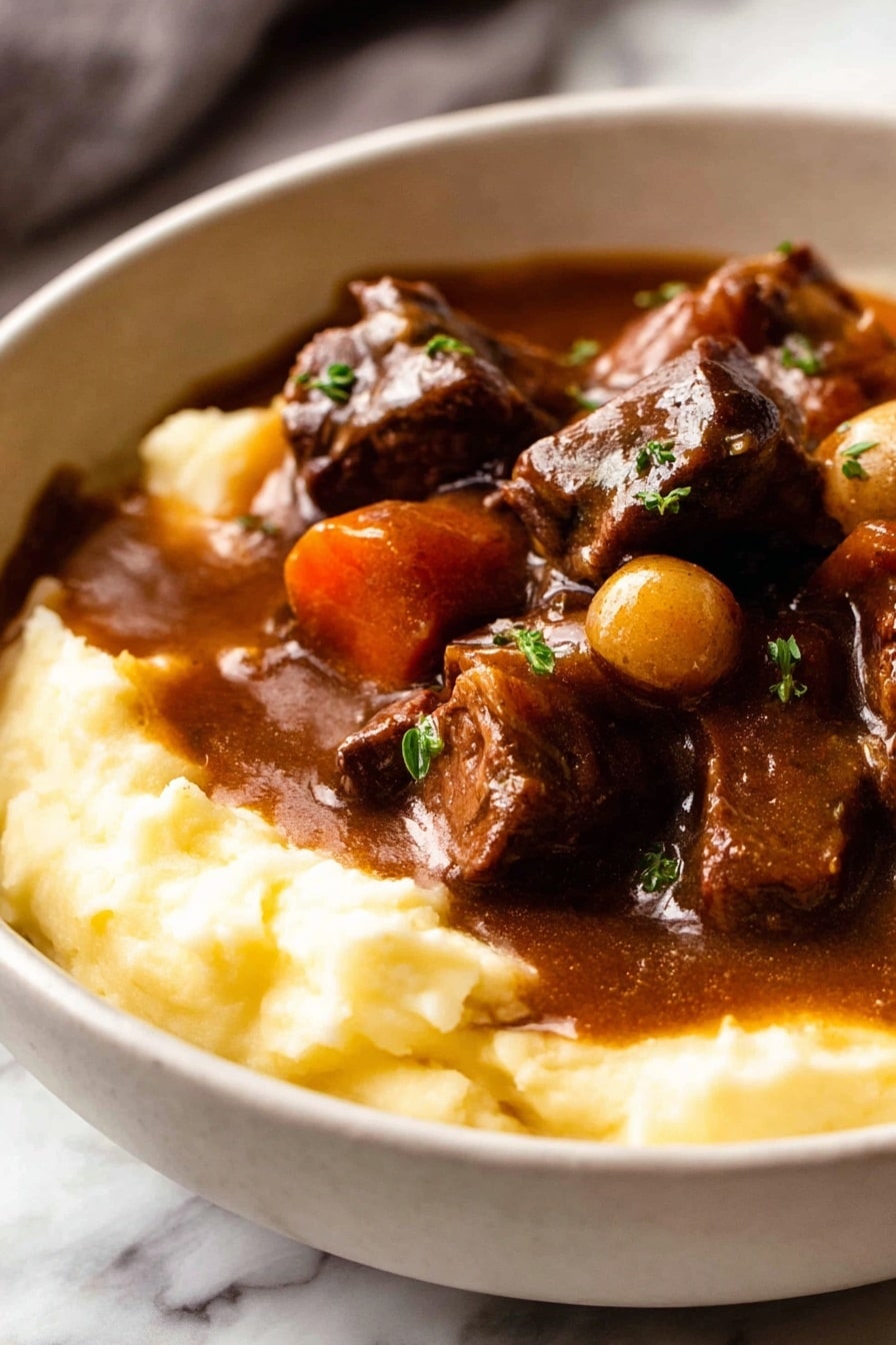 A white bowl filled with two layers: the bottom layer is smooth, creamy mashed potatoes in a light yellow color, and the top layer is a rich, dark brown stew with chunks of tender meat, whole small onions, and thick slices of carrots, all coated in a shiny gravy. The stew slightly spills over the mashed potatoes, garnished with small sprinkles of green herbs. The bowl is placed on a white marbled surface with a folded cloth and a glass of red wine slightly visible in the background along with a detailed old-fashioned spoon in front of the bowl. Photo taken with an iphone --ar 2:3 --v 7 - Beef Bourguignon, Beef Burgundy, French beef stew, Slow cooker Beef Bourguignon, Classic French recipes