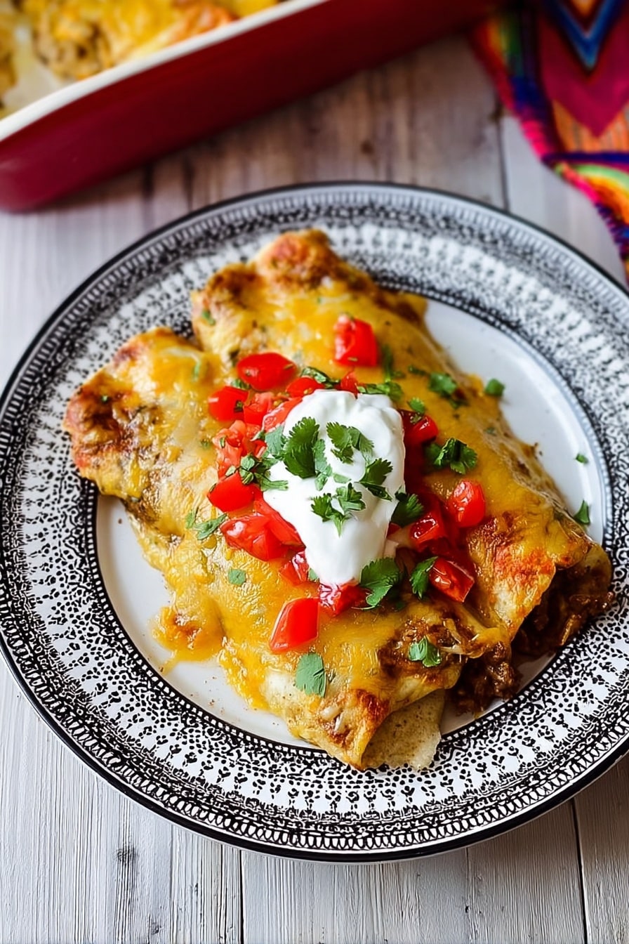A white plate with a detailed black and white pattern on the rim holds two enchiladas, each covered with melted golden-yellow cheese that has slightly browned edges. On top, there are small, bright red tomato pieces scattered along with fresh green cilantro leaves. A dollop of white sour cream sits in the center of the enchiladas. The dish rests on a white marbled surface with a wooden texture and there is a hint of a baking dish in the background. photo taken with an iphone --ar 2:3 --v 7 - Easy Chicken Enchiladas, Chicken Enchiladas, Best Chicken Enchiladas, Simple Chicken Enchiladas, Delicious Chicken Enchiladas