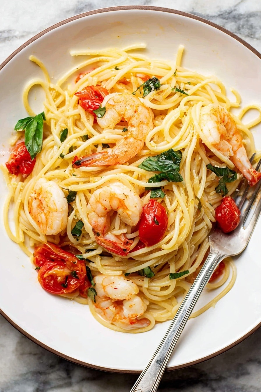 The image shows a black pan filled with cooked spaghetti pasta mixed with orange-pink shrimp and small bits of red tomato scattered throughout. Bright green basil leaves lay on top in three spots, adding fresh color. The spaghetti noodles are creamy yellow and twisted around a silver fork resting inside the pan on the right side. The pan sits on a white marbled surface with a wooden texture background faintly visible. The scene looks warm and inviting, with a mix of textures from smooth pasta to plump shrimp and torn basil leaves. Photo taken with an iphone --ar 2:3 --v 7 - Shrimp Tomato Basil Pasta, shrimp pasta with cherry tomatoes, garlic basil pasta, quick shrimp pasta recipe, summer seafood pasta