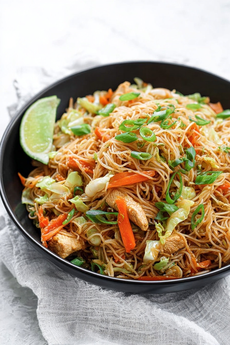 The image shows a large black wok filled with a heap of cooked thin rice noodles mixed with small pieces of light brown chicken, bright orange carrot strips, green onion stalks, and light green cabbage pieces. A woman's hand holds a wooden spatula lifting a tall mound of the noodles, showing the mix’s soft and slightly oily texture. The background has a white marbled surface with a wooden cutting board and kitchen items softly blurred. The noodles and vegetables create a colorful and textured heap inside the wok. Photo taken with an iphone --ar 2:3 --v 7 - Easy Chicken and Pork Pancit, Filipino noodle dish, quick pancit recipe, savory chicken pork stir-fry, Filipino comfort food