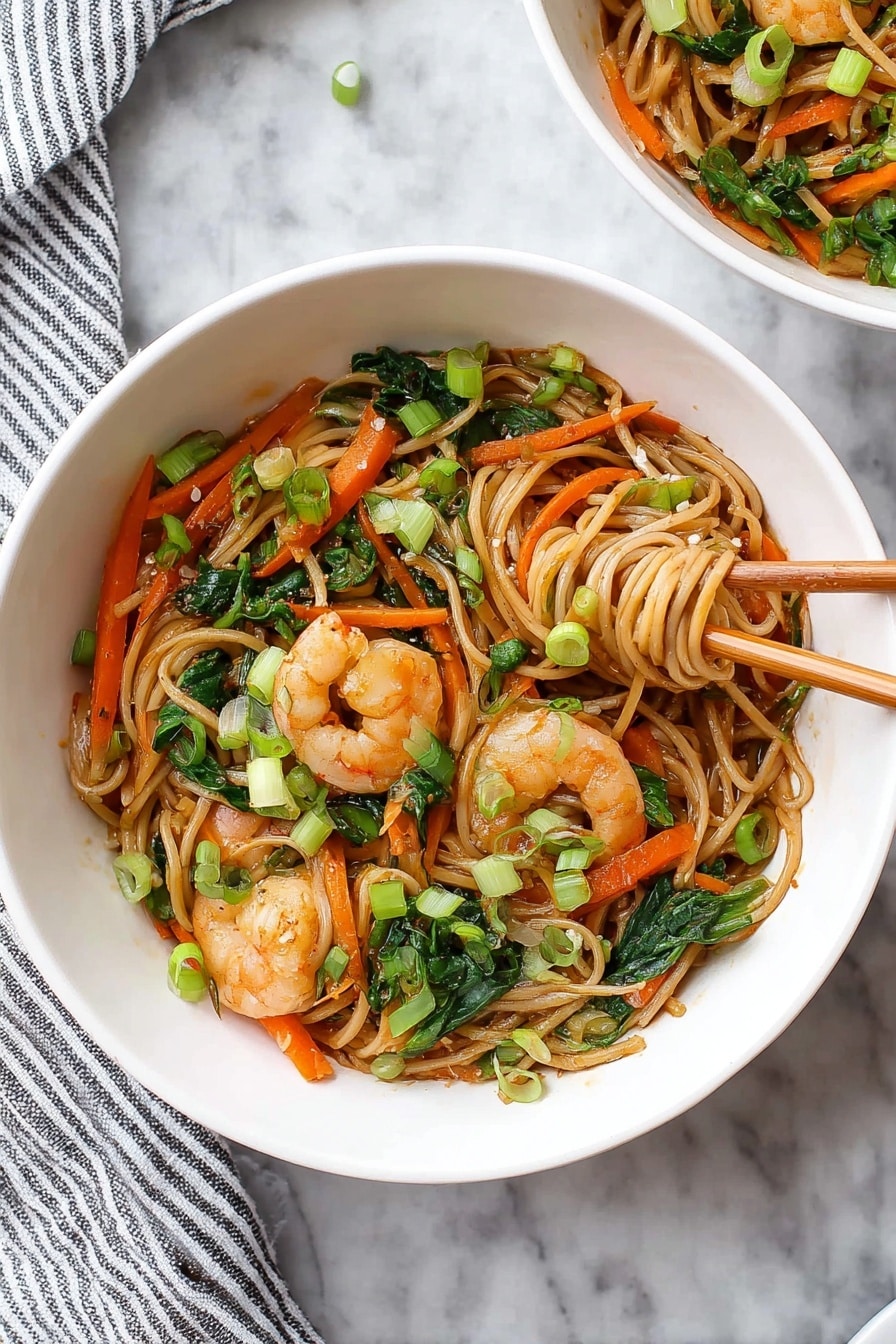 A large black pan filled with a stir-fry of light brown noodles mixed with green bok choy leaves, thin orange carrot strips, and small white chunks of bok choy stems, scattered with cooked shrimp that are pink with a slight shine. Bright green chopped scallions are sprinkled on top, adding freshness. A pair of metal tongs lifts a mix of noodles and shrimp from the pan. The pan rests on a white marbled surface with a clear glass bowl holding more chopped green scallions in the background. A beige cloth is draped on the upper left side. photo taken with an iphone --ar 2:3 --v 7 - Shrimp Lo Mein Stir-Fry, shrimp stir-fry recipe, easy lo mein recipe, healthy Asian stir-fry, quick shrimp noodle dish