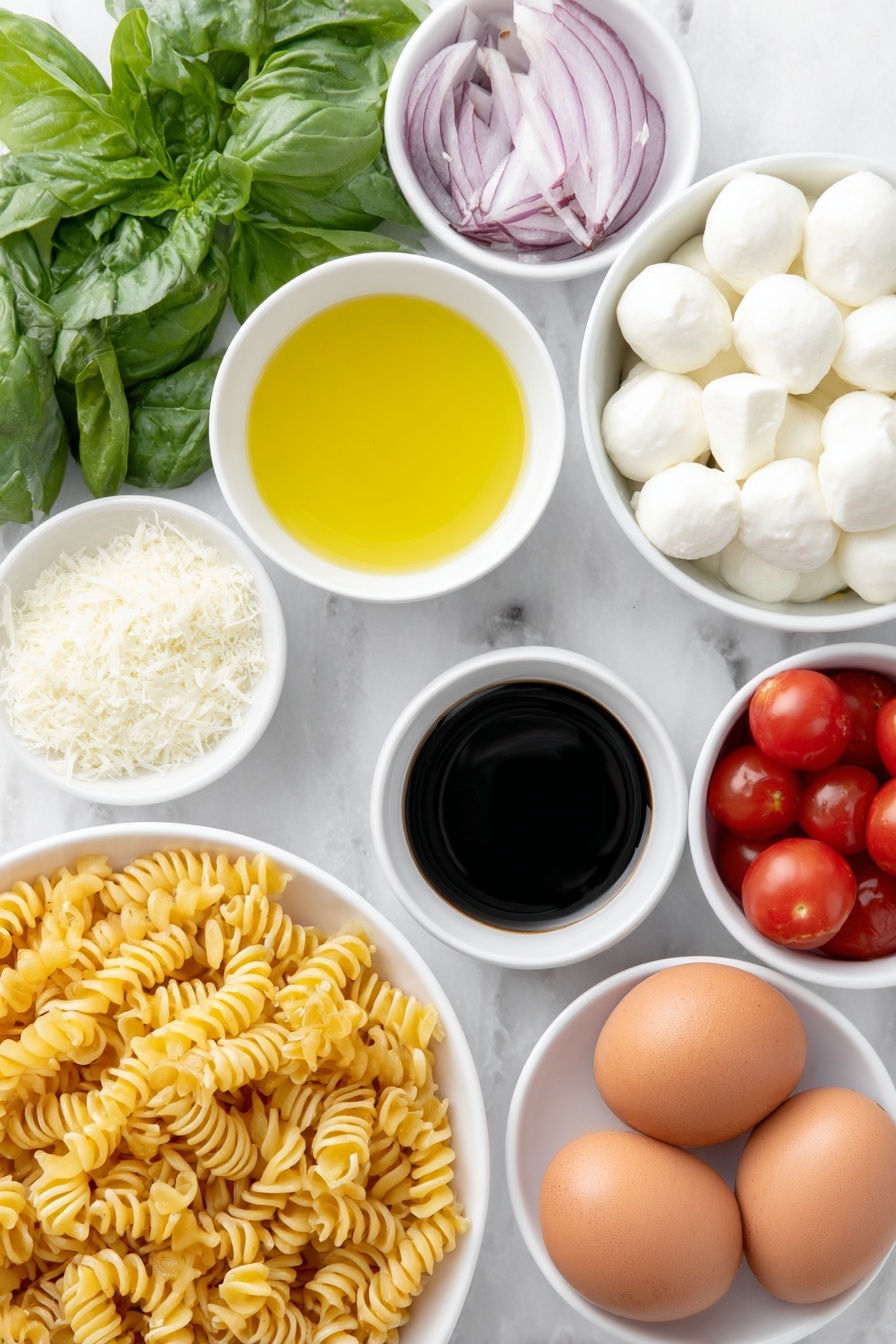 Flat lay of cavatappi pasta twisted spirals, a small white bowl of extra-virgin olive oil glistening, a small white bowl of fresh lemon juice pale yellow, a small white bowl of dark balsamic vinegar, a small white bowl of finely grated pecorino cheese light off-white, a few garlic cloves whole and peeled, a small pile of coarse sea salt crystals, a few twists of freshly ground black pepper, a handful of halved bright red cherry tomatoes, several halved mini mozzarella balls pure white and smooth, thinly sliced rings of red onion vibrant purple, a heaping handful of fresh basil leaves deep green torn and whole, several whole brown eggs with clean shells placed nearby, all arranged symmetrically on simple white ceramic bowls and plates, placed on a clean white marble surface, soft natural light, photo taken with an iPhone, professional food photography style, fresh ingredients, white ceramic bowls, no bottles, no duplicates, no utensils, no packaging --ar 2:3 --v 7 --p m7354615311229779997 - Caprese Pasta Salad, Cherry Tomato Pasta Salad, Italian Pasta Salad, Summer Pasta Salad, Fresh Basil Pasta Salad