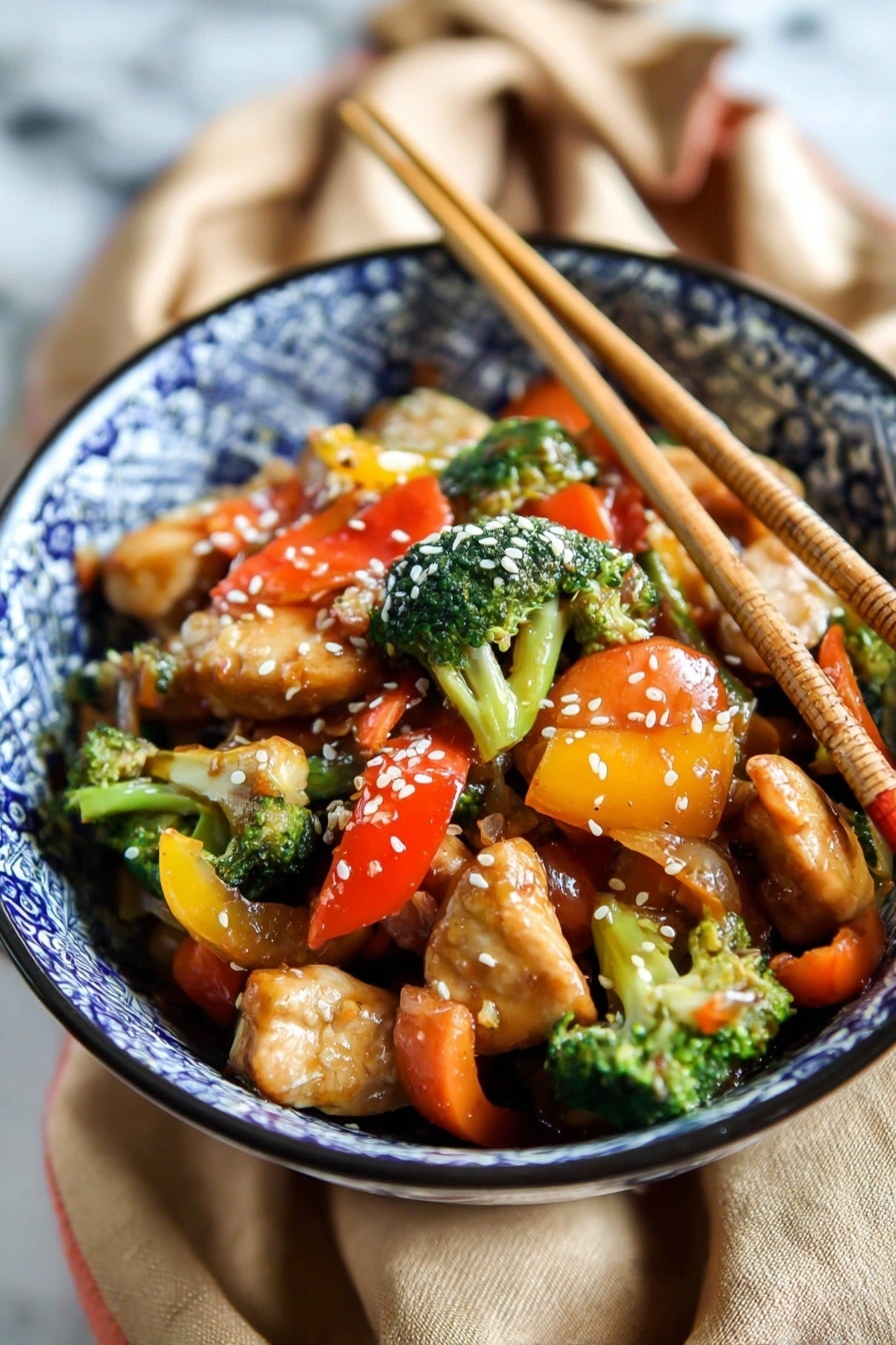 A bowl with blue and white patterned design holds a colorful stir-fry dish. The bottom layer is juicy, light brown pieces of chicken. Mixed with the chicken are bright green broccoli florets, orange carrot slices, and chunks of red and yellow bell peppers. The vegetables appear fresh and slightly glossy with sauce. White sesame seeds sprinkled on top add texture. Two wooden chopsticks stand upright in the bowl. The bowl sits on a tan fabric on a white marbled surface. Photo taken with an iphone --ar 2:3 --v 7 - Easy Chicken Stir Fry without recipe, healthy chicken stir fry, quick stir fry ideas, vegetable stir fry, simple dinner recipes