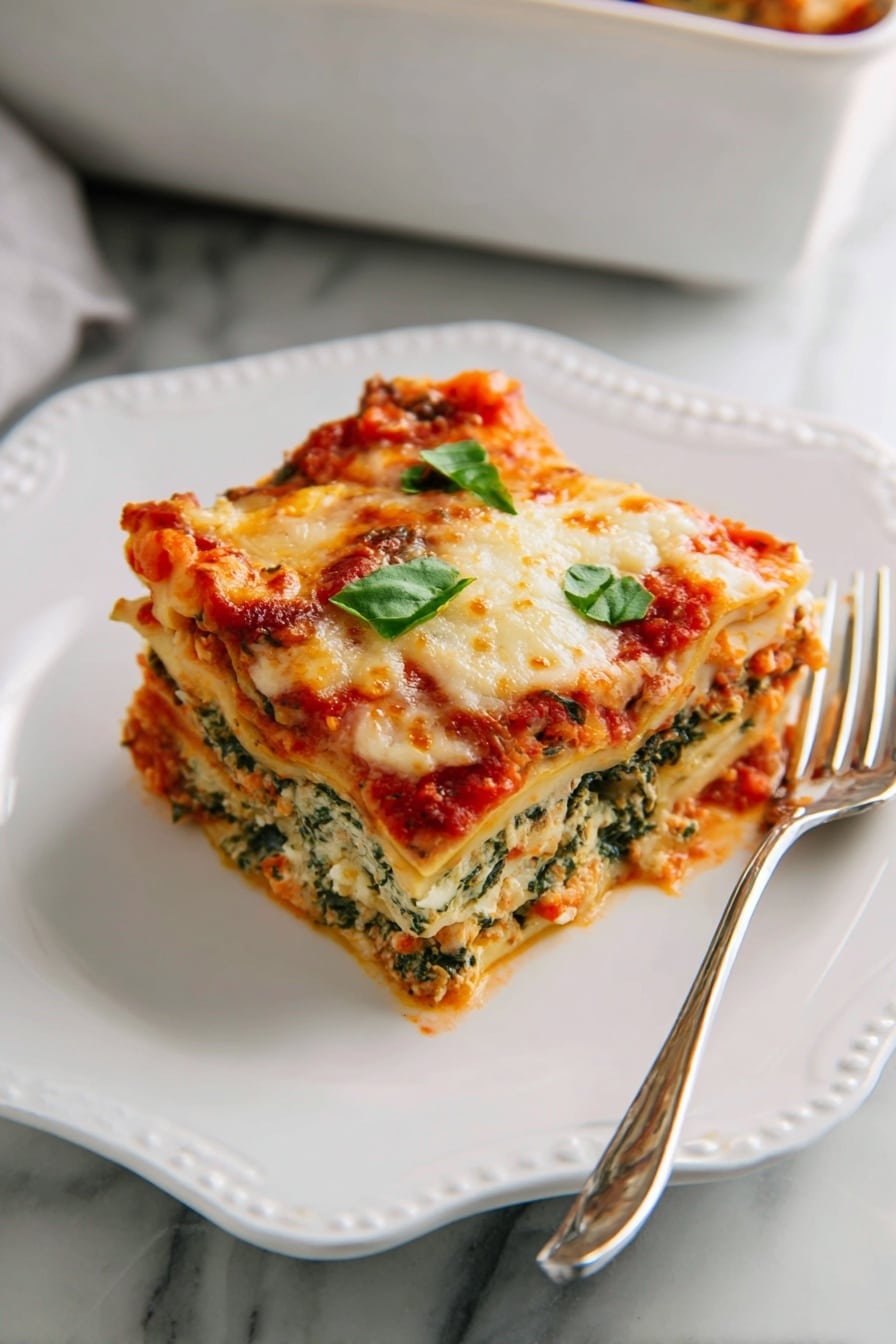 A white square baking dish holds a fresh lasagna with visible layers of rich red tomato sauce mixed with meat and bits of yellow pasta beneath a thick, bubbly layer of melted cheese that is golden brown in spots. Bright green chopped basil leaves are sprinkled over the top, adding fresh color and shine. The dish rests on a soft dark blue cloth on a white marbled surface, and extra basil leaves are placed beside it, creating a clean and inviting look. Photo taken with an iphone --ar 2:3 --v 7 - Spinach Artichoke Lasagna, healthy spinach lasagna, veggie lasagna recipe, easy vegetable lasagna, cheesy spinach artichoke bake