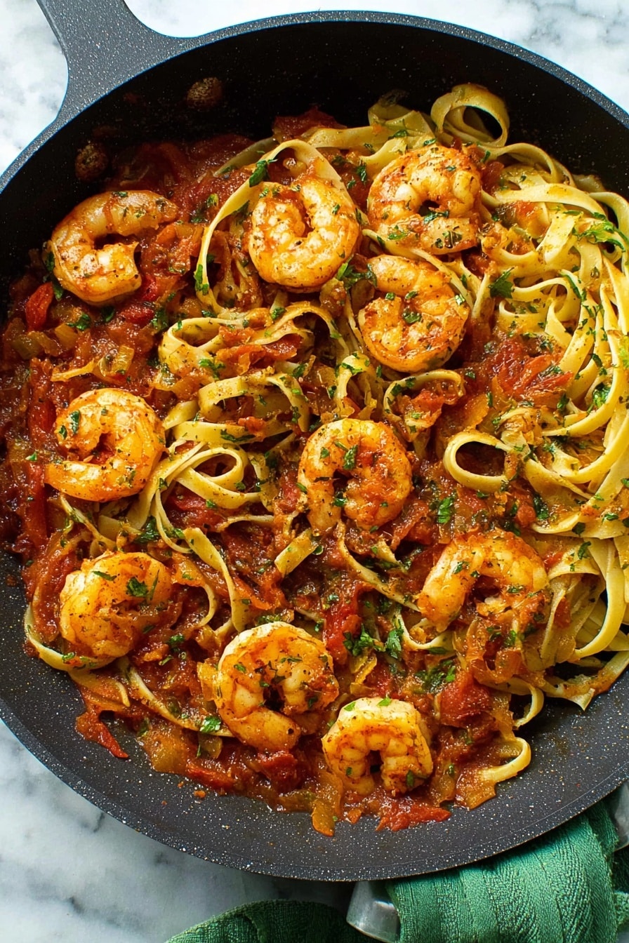 The image shows a white bowl filled with pasta and shrimp. The pasta is light yellow and soft-looking, with a few pieces twisted and layered all over. On top, there are five shrimp, cooked to a golden orange color with a slightly crispy texture. Small pieces of red tomato and green herbs are mixed in among the pasta, adding bright color spots. A silver fork is placed inside the bowl, with its handle pointing outwards. The bowl sits on a white marbled surface with small red chili flakes scattered around. Photo taken with an iphone --ar 2:3 --v 7 - Spicy Shrimp Fra Diavolo with Tomato Sauce, shrimp fra diavolo recipe, spicy seafood pasta, easy shrimp tomato sauce, fiery shrimp recipes