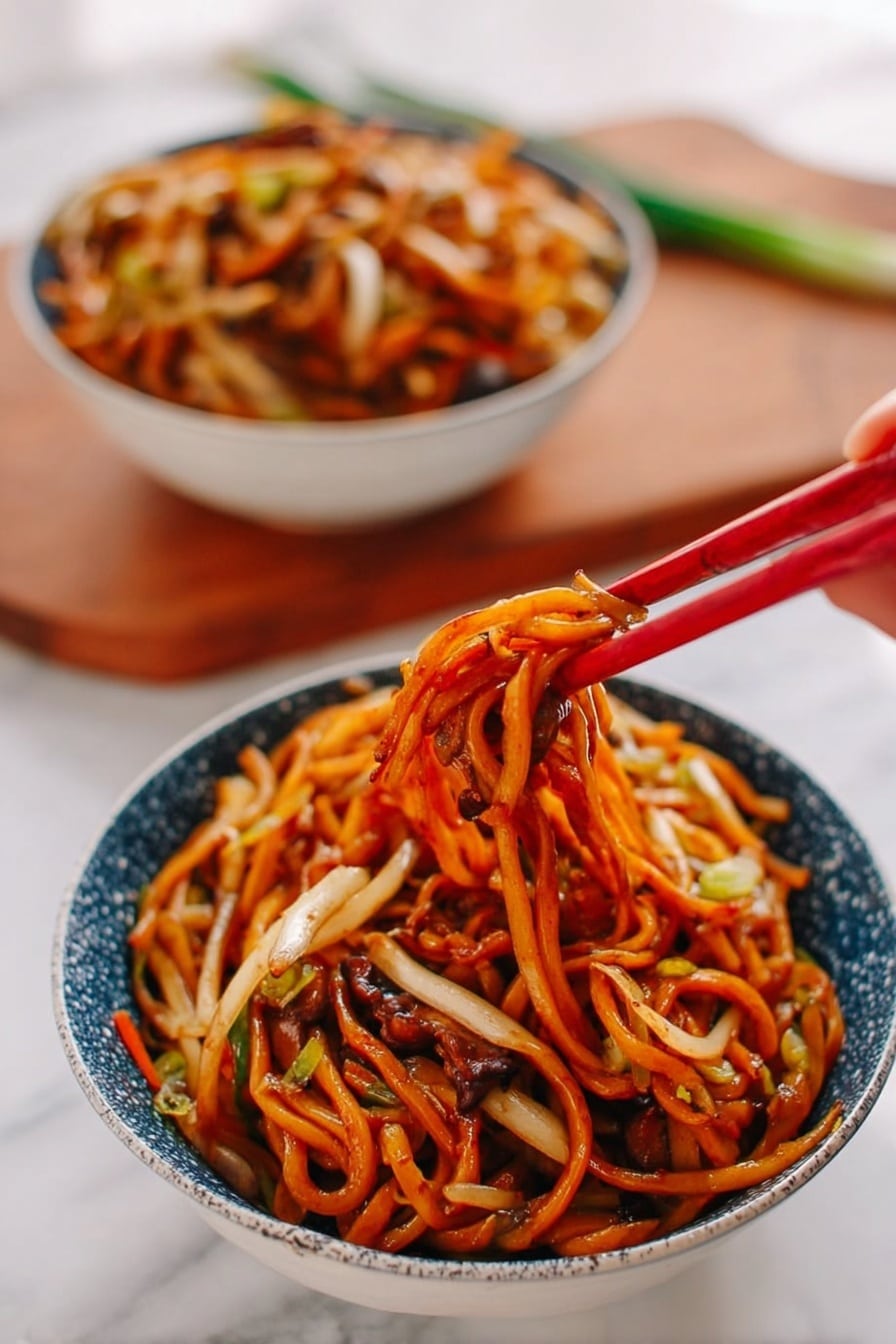 A bowl of noodles sits on a white marbled surface, filled with thick, orange-brown noodles mixed with thin white and light tan vegetables, all coated in a shiny sauce. A woman's hand is holding red chopsticks lifting a tangled cluster of noodles with bits of vegetables and darker brown mushroom-like pieces peeking through. In the background, another bowl filled with the same noodle dish is slightly blurred. The bowls are white with a blue speckled pattern on the outside, and a wooden cutting board with some green onion is faintly seen behind them. photo taken with an iphone --ar 2:3 --v 7 - Chicken Lo Mein Dinner, Easy Chicken Lo Mein, Authentic Chicken Lo Mein, Quick Chinese Noodles, Homemade Lo Mein