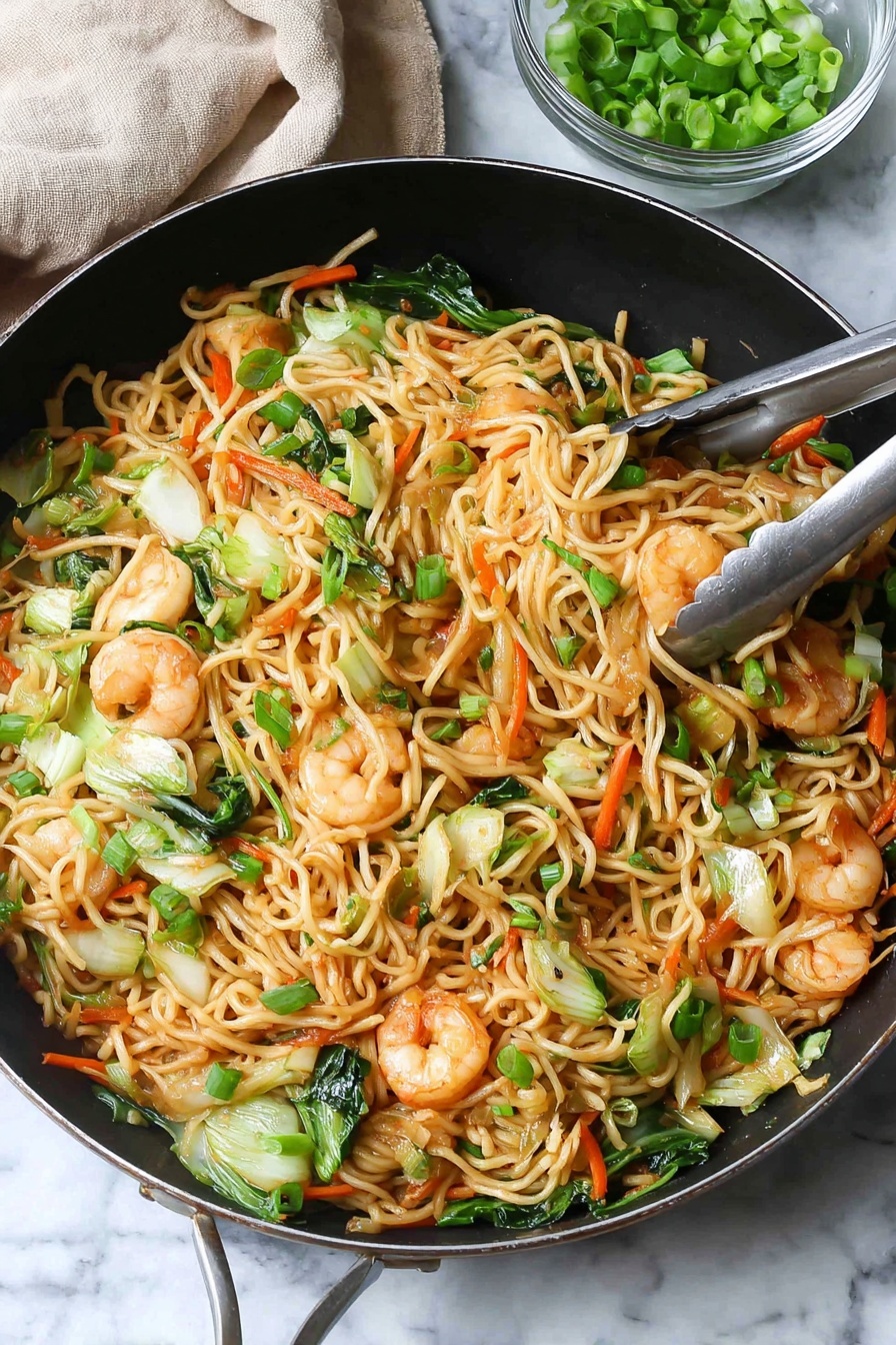 A large black pan is filled with a colorful stir-fry of noodles, shrimp, and vegetables. The base layer has light brown noodles that are thin and mixed with bright green pieces of bok choy and carrot sticks in orange. On top are pink shrimp, slightly browned with black pepper sprinkled on them, scattered throughout. Small pieces of green onions are spread over the whole dish, adding fresh green color. Chopsticks hold a small bundle of noodles and shrimp above the pan. In the background, a small clear glass bowl holds more green onions, and a light wooden pepper grinder is visible. The scene sits on a white marbled textured surface with a light gray cloth napkin beside the pan photo taken with an iphone --ar 2:3 --v 7 - Shrimp Lo Mein Stir-Fry, shrimp stir-fry recipe, easy lo mein recipe, healthy Asian stir-fry, quick shrimp noodle dish