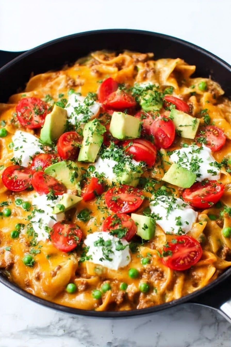 A black cast iron pan filled with a layered baked pasta dish topped with melted bright orange cheese, scattered green chopped herbs, and chopped green onions. On top are halved red cherry tomatoes, chunks of light green avocado, and dollops of white sour cream. A wooden spoon is scooping some of the pasta from the right side, showing short tube-shaped pasta mixed with meat and sauce underneath the cheese layer. The whole scene is set on a white marbled surface. photo taken with an iphone --ar 2:3 --v 7 - Cheesy Enchilada Pasta, enchilada pasta recipe, cheesy pasta dishes, quick weeknight dinner, comforting pasta recipes