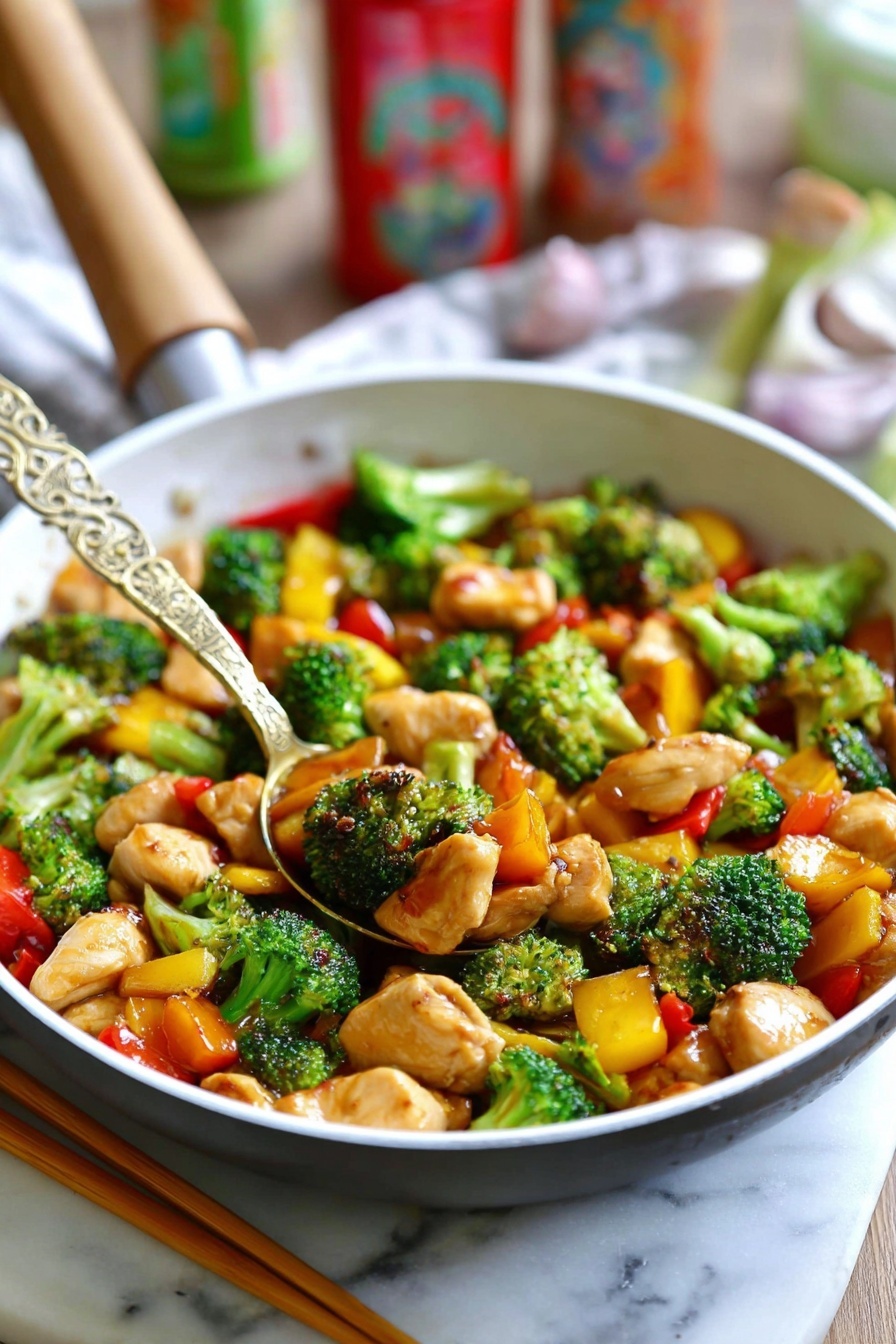 The image shows a white pan filled with a colorful stir-fry dish. The dish has three main layers: bright green broccoli florets with a fresh, bumpy texture, orange and yellow bell pepper pieces adding vibrant color and a slightly glossy texture, and light brown chicken pieces with a tender, soft look. A golden spoon with an intricate design rests in the middle of the pan, lifting some of the stir-fry. The whole scene is set on a white marbled surface, with a pair of wooden chopsticks lying beside the pan. In the background, some blurred colorful kitchen items add a cozy feel. Photo taken with an iphone --ar 2:3 --v 7 - Easy Chicken Stir Fry without recipe, healthy chicken stir fry, quick stir fry ideas, vegetable stir fry, simple dinner recipes
