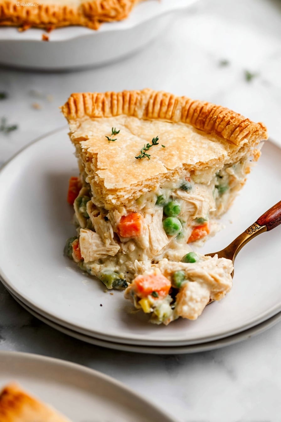 A slice of chicken pot pie with three layers sits on a white plate over another white plate on a white marbled surface. The first layer is a golden brown, firm, slightly cracked top pie crust with a few small green herb sprigs on it. The second layer is a creamy filling with soft white chicken chunks, orange carrot pieces, and bright green peas visible. The third layer is a thick, golden brown crust on the edge, textured with vertical ridges from being pressed down. A fork with a wooden handle holds some filling, resting next to the pie slice on the plate. Photo taken with an iphone --ar 2:3 --v 7 - Homestyle Double Crust Chicken Pot Pie, homemade chicken pot pie with flaky crust, easy chicken pot pie recipe, comforting chicken pot pie dish, hearty chicken pie with vegetables