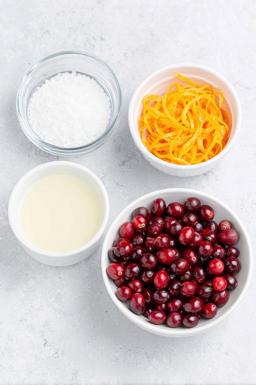 Flat lay of fresh, glossy red cranberries scattered alongside a small white ceramic bowl filled with granulated white sugar, a small white ceramic bowl containing bright, freshly squeezed orange juice, a simple white ceramic bowl with clear water, and a neat pile of vibrant orange zest strips, all arranged with perfect symmetry on a clean white marble surface, soft natural light, photo taken with an iPhone, professional food photography style, fresh ingredients, white ceramic bowls, no bottles, no duplicates, no utensils, no packaging --ar 2:3 --v 7 --p m7354615311229779997 - Easy Homemade Cranberry Sauce, cranberry sauce recipe, holiday cranberry sauce, fresh cranberry sauce, quick homemade cranberry sauce