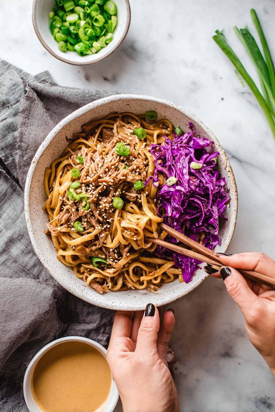 A white speckled bowl filled with a mix of thick, light brown noodles on top, shredded pieces of light brown meat underneath, and bright purple cabbage scattered on the right side and mixed throughout. Light green sliced scallions are sprinkled on top along with small white sesame seeds. A woman's hand holds the bowl from the bottom, while another woman's hand with dark nail polish uses wooden chopsticks to pick up some purple cabbage from the edge of the bowl. Nearby are two small white bowls, one with chopped green scallions and the other with a creamy light brown sauce. The setting is on a white marbled surface with a gray cloth under the bowl, and some scallions lie on the top right side. Photo taken with an iphone --ar 2:3 --v 7 - Thai Peanut Chicken Noodles, Thai peanut noodles, Chicken noodle stir-fry, Creamy peanut sauce recipes, Easy Asian chicken dishes