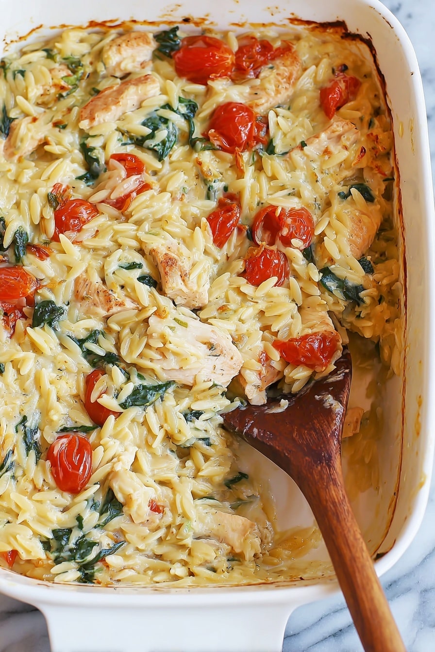 A white baking dish filled with a creamy baked pasta dish, showing about two layers with a scoop taken out from the bottom right side. The top layer has creamy, yellowish orzo pasta mixed with small roasted cherry tomatoes, chunks of light brown cooked chicken pieces, and green spinach leaves, all coated in a creamy sauce. The sides of the dish show some baked brown edges where the sauce has slightly caramelized. A wooden spoon with a long handle is inside the dish, partially covered in the pasta mixture. The dish is placed on a white marbled surface. Photo taken with an iphone --ar 2:3 --v 7 - Creamy Chicken Orzo Bake, easy chicken orzo casserole, cheesy chicken pasta bake, hearty chicken and orzo dish, baked chicken with tomatoes and spinach