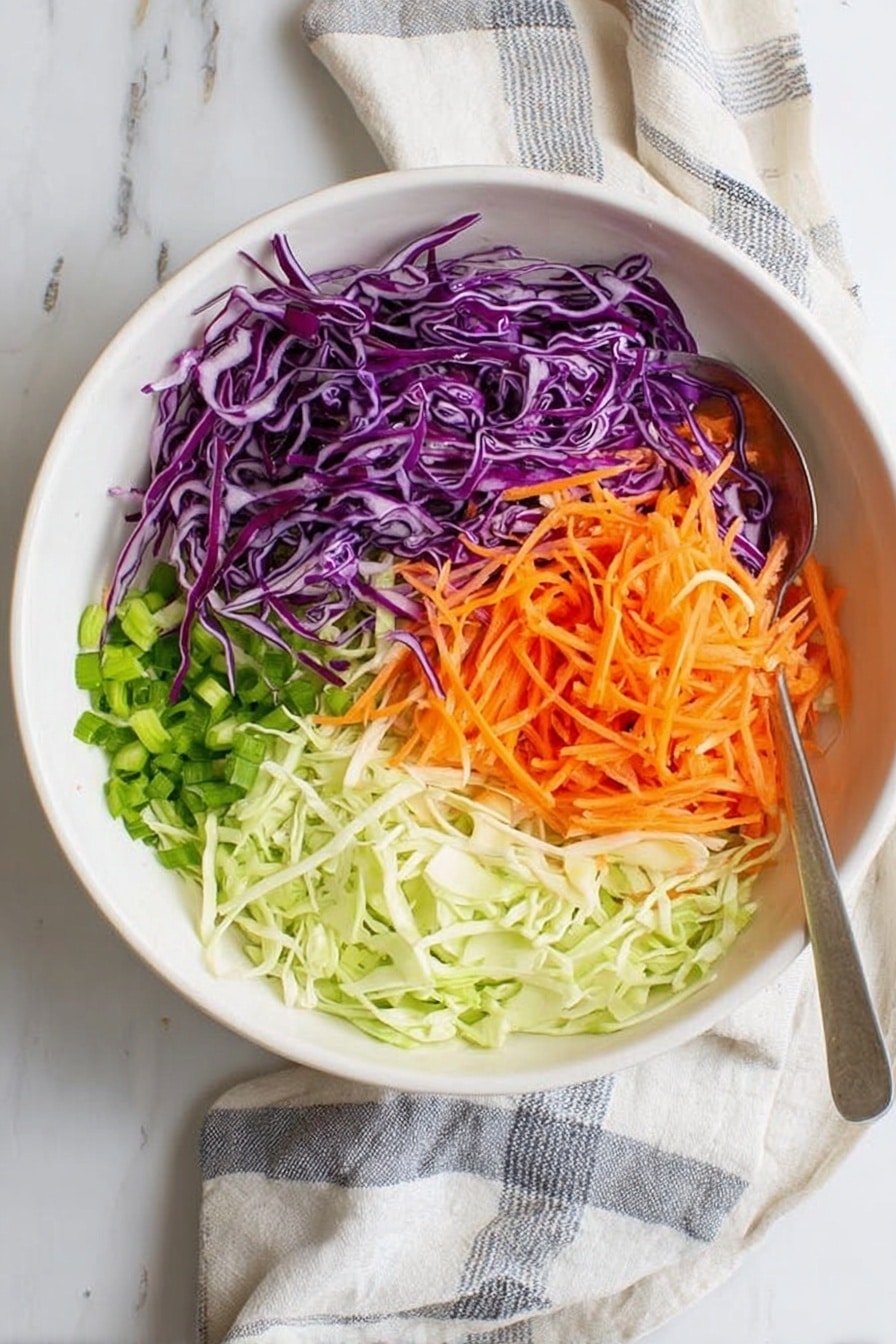 A white bowl on a white marbled surface holds four distinct layers of fresh, thinly shredded vegetables arranged side by side. On the left is shredded purple cabbage with a few green pieces mixed in. To its right is bright orange shredded carrot, slightly overlapping some pieces of purple cabbage. Below the cabbage, finely chopped green onions form the third layer, and next to them, on the bottom right, is a pile of thinly shredded light green cabbage. A silver spoon lies on the surface near the bowl, and a white cloth with gray stripes is partially visible under the bowl. Photo taken with an iphone --ar 2:3 --v 7 - Southern Collard Greens, Collard Greens Recipe, Soul Food Collard Greens, Southern Green Side Dish, Easy Collard Greens