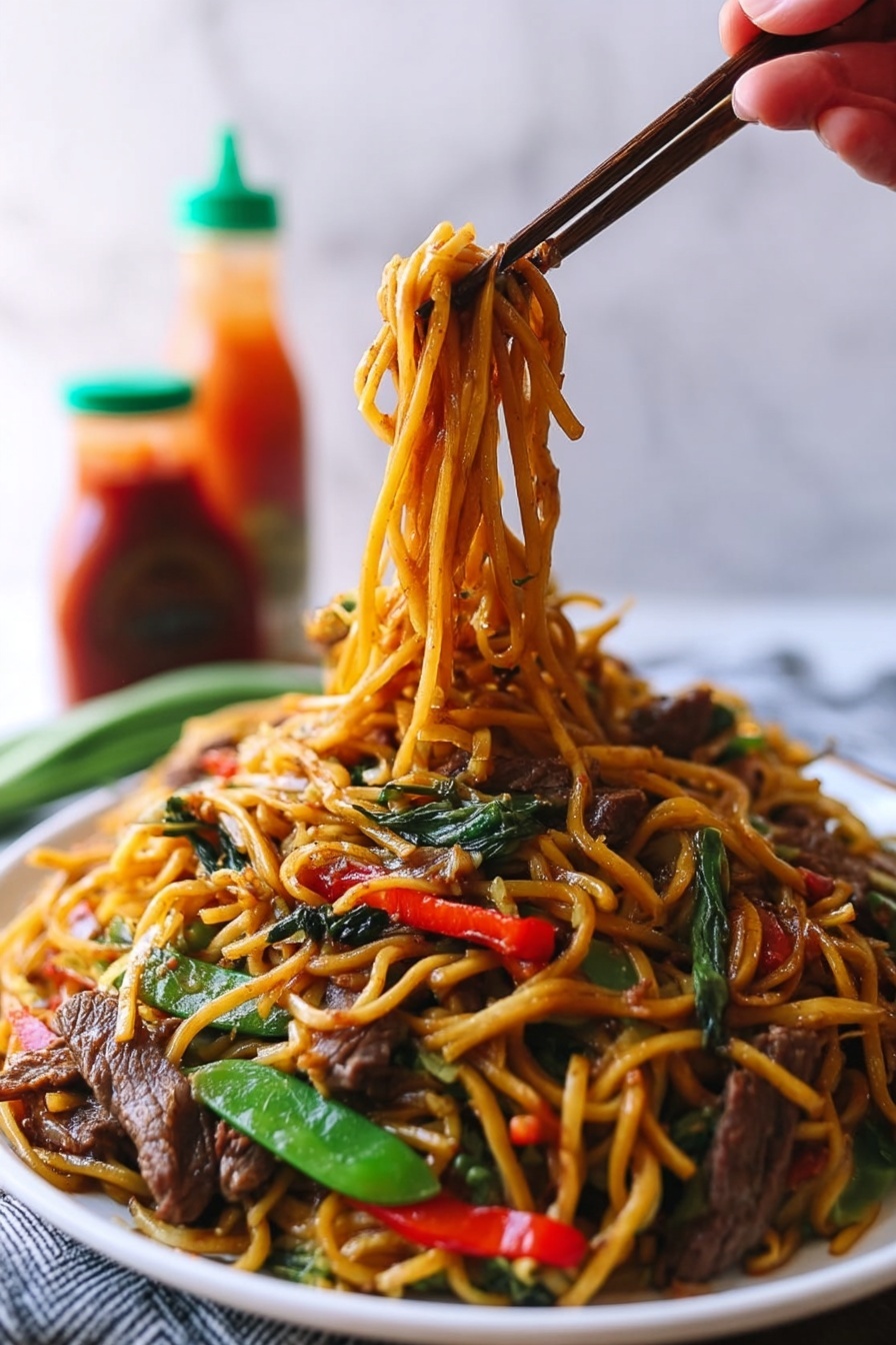 A large white plate holds a colorful stir-fry noodle dish with multiple layers. The bottom layer is long, yellow-brown noodles, glossy from sauce and slightly twisted. Mixed into the noodles are bright green snap peas and long, thin red bell pepper slices adding color contrast. Thin strips of cooked brown beef are scattered evenly on top, along with thin white strands of bean sprouts providing texture. The dish sits on a white marbled surface with blurred background that includes a blue and white bowl and bottles of sauce. photo taken with an iphone --ar 2:3 --v 7 - Beef Lo Mein Stir-Fry, beef lo mein recipe, easy beef lo mein, quick stir-fry noodle dish, homemade lo mein with beef