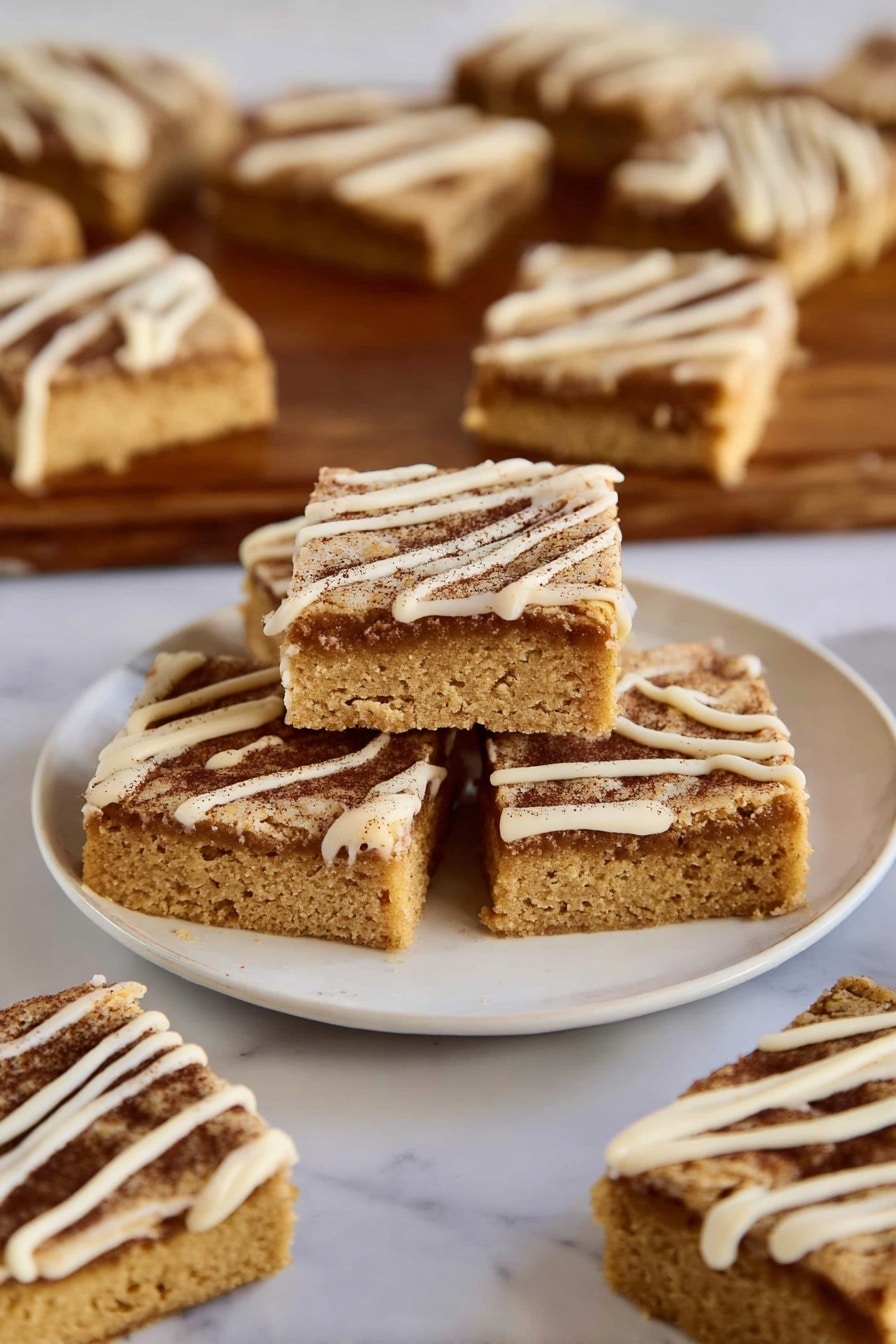 The image shows several square-shaped blondies with two visible layers: a thick golden-brown base with a soft texture and a darker cinnamon-brown sugar layer on top, sprinkled with a thin drizzle of creamy white icing forming diagonal lines. Three blondies are stacked in the center of a white plate, with more pieces spread around on the same plate and on a wooden board in the background, all placed on a white marbled surface. photo taken with an iphone --ar 2:3 --v 7 - Cinnamon Sugar Blondies, Cinnamon Blondies recipe, easy blondie dessert, cinnamon bar treats, cozy cinnamon sweets