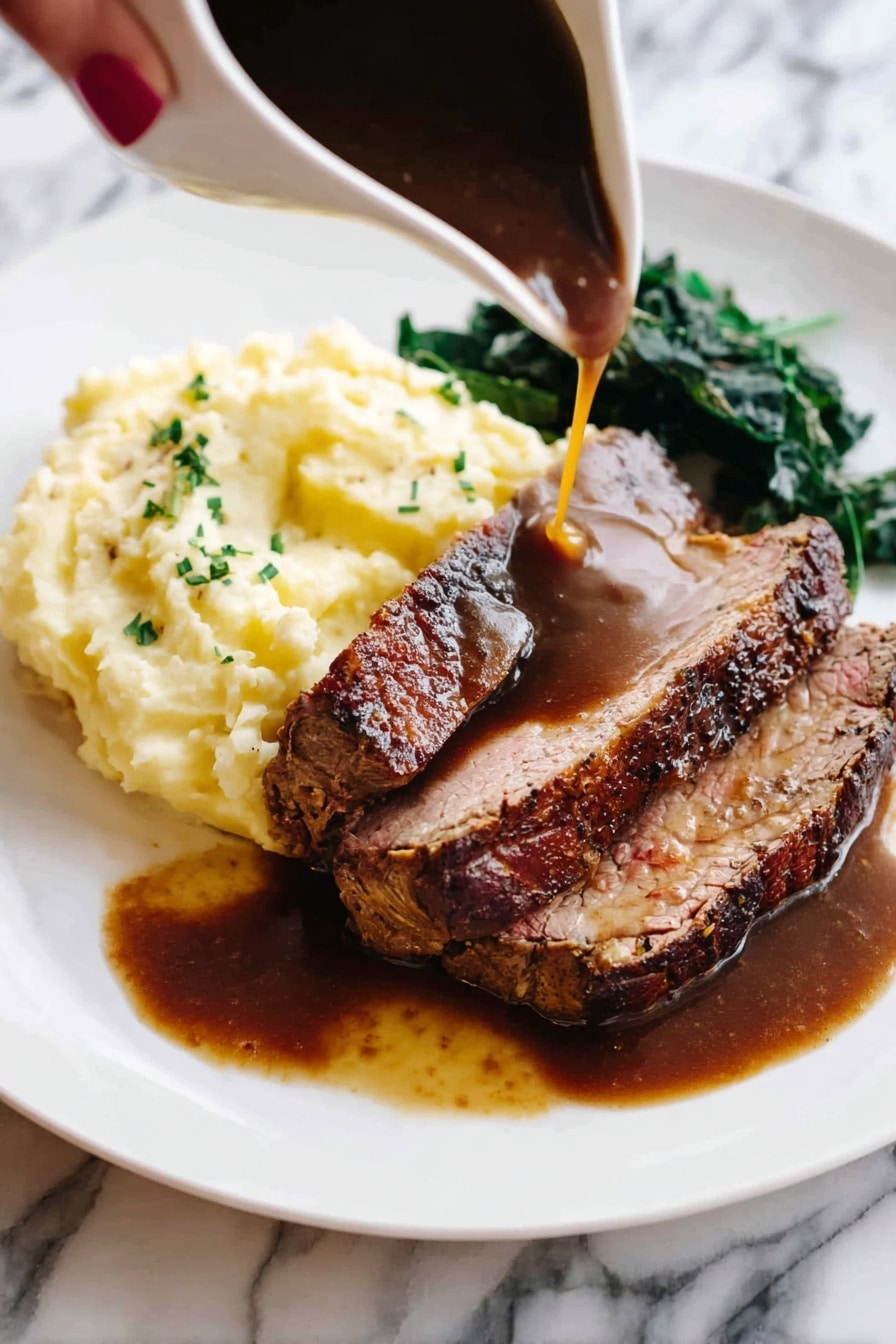 A white plate holds a serving of meat with a dark brown crust and tender pink inside, sliced to show two thick layers of meat. The meat rests partly on a mound of creamy pale yellow mashed potatoes with a slight shine and scattered green herbs on top. To one side, there is a small portion of dark green leafy vegetables. A woman's hand pours a smooth, rich dark brown sauce over the meat, some of the sauce pooling on the plate. The background features a white marbled surface. Photo taken with an iphone --ar 2:3 --v 7 - Perfect Prime Rib Roast, prime rib cooking tips, juicy prime rib recipe, easy prime rib instructions, holiday prime rib roast