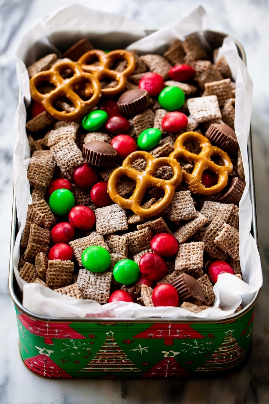 A rectangular tin with Christmas tree designs on the sides holds a festive snack mix. The mix contains many layers of square, brown, sugar-coated cereal pieces forming the base layer. Scattered on top are bright red and green candy-coated chocolates, some round and some smaller. Large golden-brown pretzels are placed unevenly across the top layer, along with several small, smooth milk chocolate peanut butter cups. The tin is lined with white parchment paper that spills over the edges slightly, all set on a white marbled surface. photo taken with an iphone --ar 2:3 --v 7 - Chocolate Peanut Butter Reindeer Chow, holiday snack, Christmas treat, festive snack recipe, no-bake holiday dessert