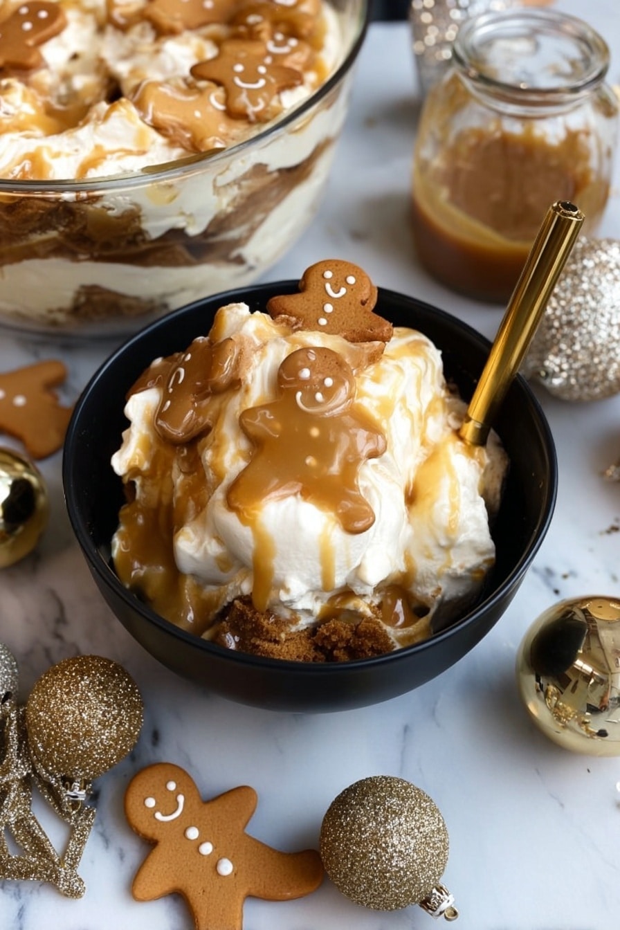 A black bowl filled with a layered dessert featuring white cream or marshmallow at the top, drizzled with light brown caramel sauce, and topped with small gingerbread man cookies that have a light brown color and smiling faces. The dessert shows a darker brown crumbly layer near the bottom contrasting with the creamy top. The bowl is placed on a white marbled surface, surrounded by more gingerbread cookies shaped like men and bells, along with two sparkly gold ornaments and a small jar of caramel sauce beside the bowl. A gold spoon rests inside the bowl, slightly submerged in the dessert. In the background, a glass bowl holds more of the same layered dessert. Photo taken with an iphone --ar 2:3 --v 7 - Gingerbread Trifle with Custard and Caramel, holiday dessert recipes, festive gingerbread dessert, layered holiday trifle, easy Christmas trifle dessert