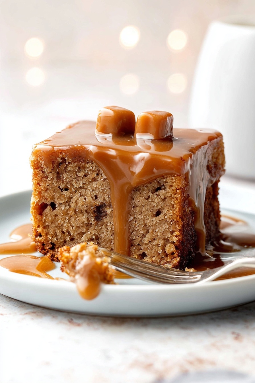 The image shows a square piece of light brown cake with visible texture and small darker spots inside, placed on a white plate. The cake has a layer of shiny caramel sauce dripping down its sides, slightly pooling on the plate. On top of the cake, there are two small, light tan caramel candies. A fork lies on the right side of the plate, with a small bite of the cake covered with caramel sauce resting near it. The background has a white marbled texture and soft bokeh light effects. Photo taken with an iphone --ar 2:3 --v 7 - Sticky Toffee Pudding with English Toffee Sauce, British toffee dessert, easy sticky toffee pudding recipe, moist date pudding with toffee sauce, cozy British desserts