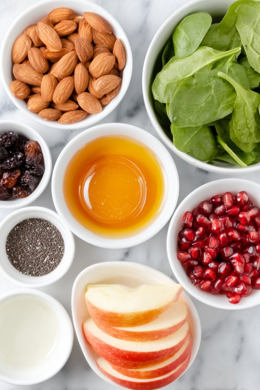 Flat lay of slivered almonds, small white bowl of extra virgin olive oil, small white bowl of honey, small white bowl of kosher salt, small white bowl of dried cranberries, small white bowl of water, small white bowl of apple cider vinegar, medium clove of garlic, small white bowl of freshly ground black pepper, small white bowl of poppy seeds, large bunch of fresh baby spinach leaves, large crisp red apple thinly sliced, small white bowl of bright red pomegranate arils, whole uncracked brown eggs absent (none in recipe) placed on a clean white marble surface, soft natural light, photo taken with an iPhone, professional food photography style, fresh ingredients, white ceramic bowls, no bottles, no duplicates, no utensils, no packaging --ar 2:3 --v 7 --p m7354615311229779997 - Apple Cranberry Spinach Salad, healthy fruit and vegetable salad, easy holiday salad recipe, fresh winter salad, nutritious spinach salad