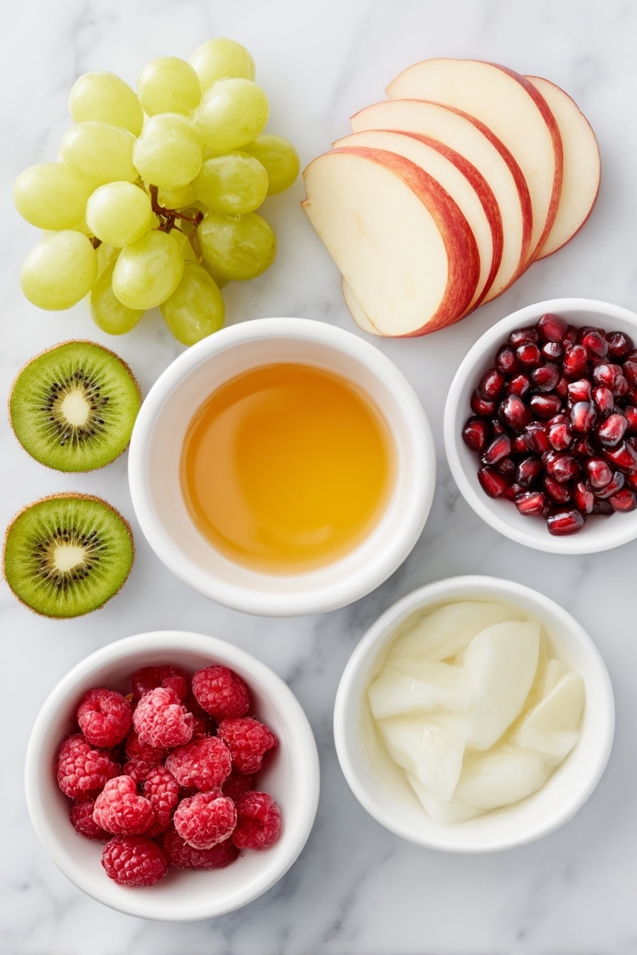 Flat lay of a sliced Granny Smith apple with bright green flesh and crisp skin, a sliced red apple with vibrant red and white contrast, a small cluster of fresh green grapes, a small cluster of fresh red grapes, two peeled and sliced kiwi showing vivid green flesh with black seeds, a handful of plump red raspberries, a small pile of shiny pomegranate arils, a small white ceramic bowl filled with golden honey, a small white ceramic bowl with fresh lime juice, a small white ceramic bowl of clear water, all arranged in perfect symmetry, placed on a clean white marble surface, soft natural light, photo taken with an iPhone, professional food photography style, fresh ingredients, white ceramic bowls, no bottles, no duplicates, no utensils, no packaging --ar 2:3 --v 7 --p m7354615311229779997 - Festive Christmas Fruit Salad, holiday fruit salad, Christmas fruit salad, easy holiday desserts, healthy Christmas treat