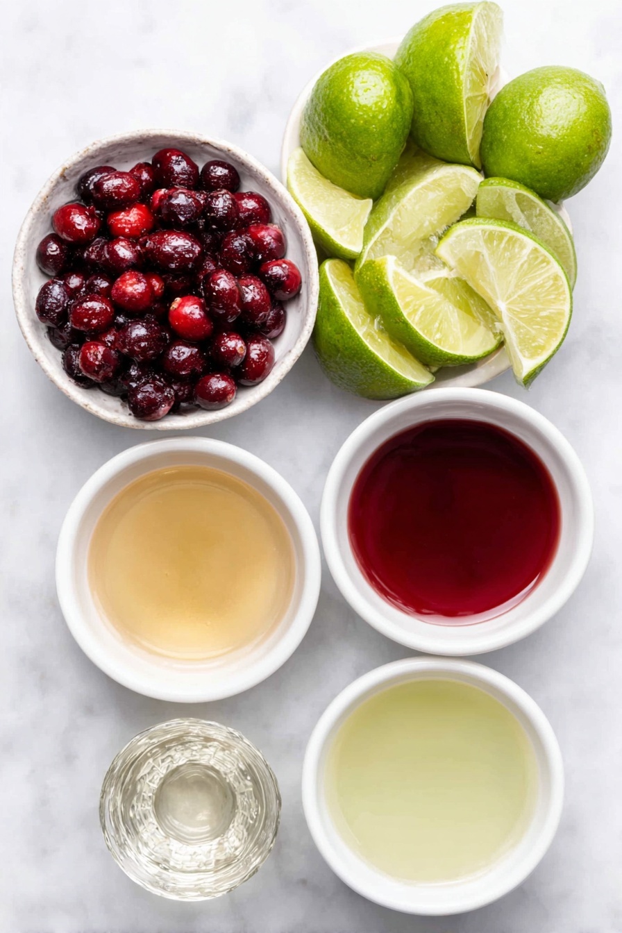 Flat lay of fresh whole lime wedges arranged neatly, a small white ceramic bowl filled with bright red fresh cranberries, a small white bowl containing clear simple syrup, a small white bowl of vibrant red cranberry juice, a small white bowl of pale green fresh lime juice, and a small white bowl with clear silver tequila, placed on a clean white marble surface, soft natural light, photo taken with an iPhone, professional food photography style, fresh ingredients, white ceramic bowls, no bottles, no duplicates, no utensils, no packaging --ar 2:3 --v 7 --p m7354615311229779997 - Festive Cranberry Margarita, holiday margarita recipe, cranberry margarita, holiday cocktail, easy festive drinks