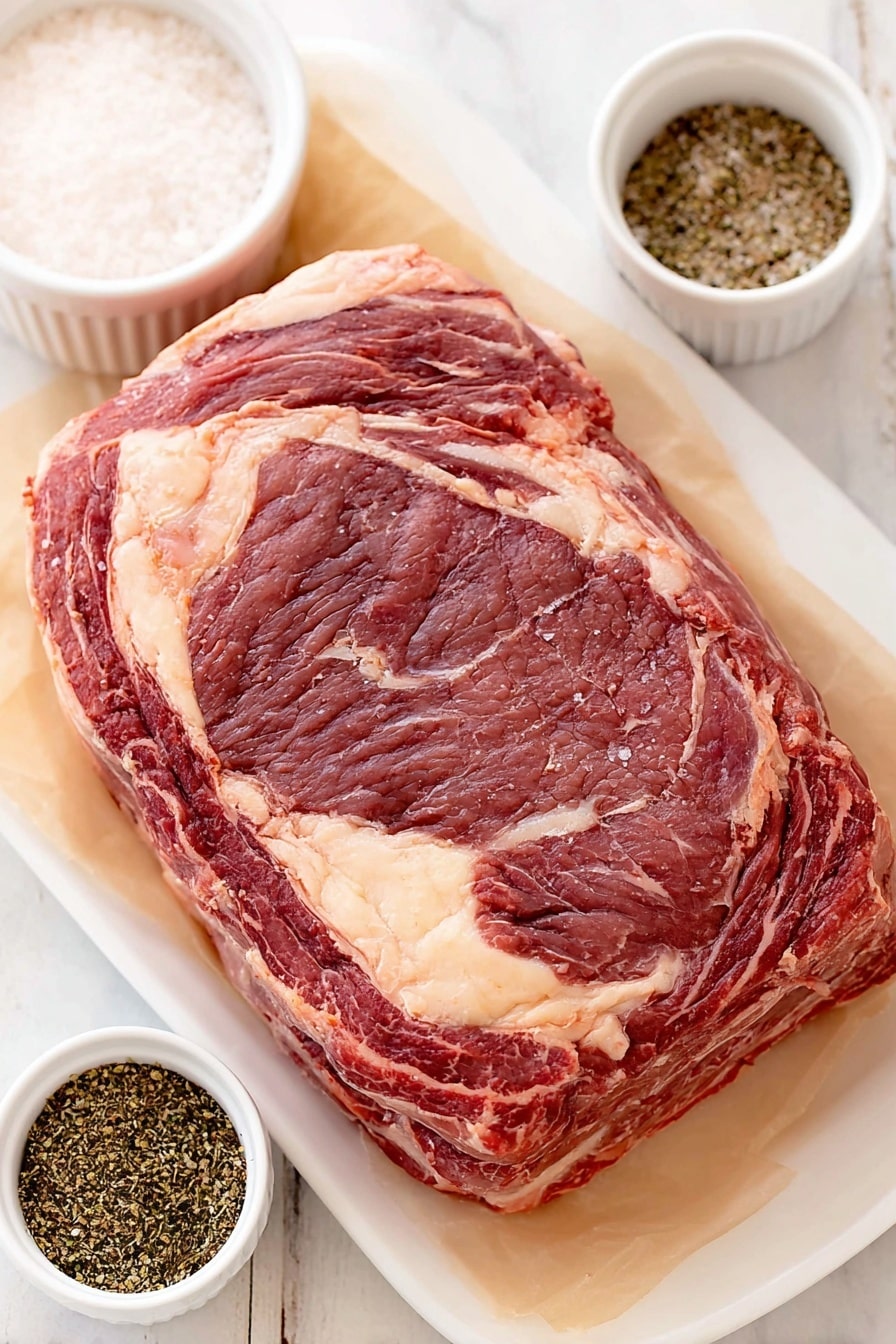 Flat lay of a large, raw standing rib roast with visible marbling and a thick fat cap, a small white ceramic bowl of coarse kosher salt, a small white ceramic bowl of freshly ground black pepper, placed on a clean white marble surface, soft natural light, photo taken with an iPhone, professional food photography style, fresh ingredients, white ceramic bowls, no bottles, no duplicates, no utensils, no packaging --ar 2:3 --v 7 --p m7354615311229779997 - Perfect Prime Rib Roast, prime rib cooking tips, juicy prime rib recipe, easy prime rib instructions, holiday prime rib roast
