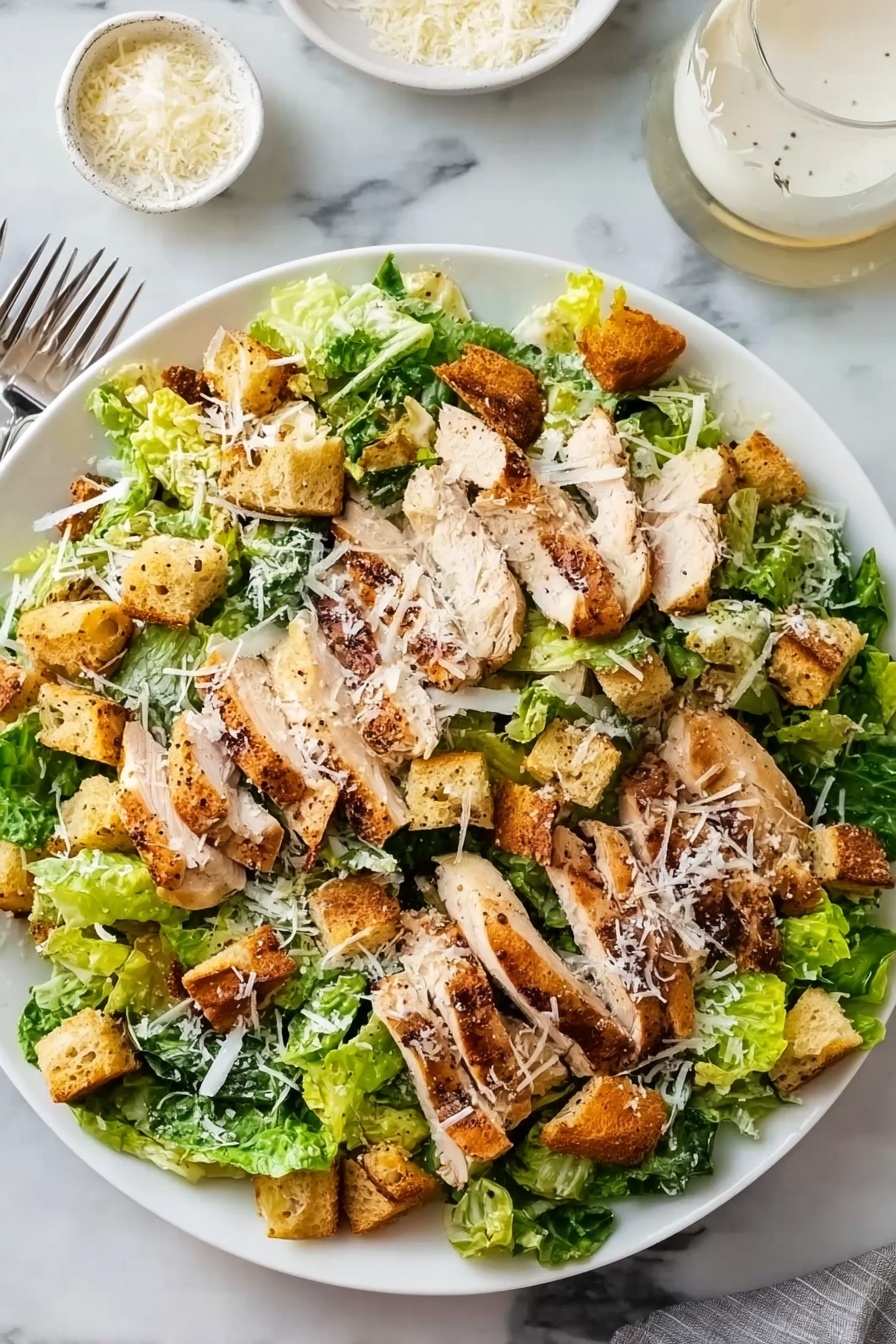 A large white plate holds a fresh salad with several layers: the bottom layer is a mix of crisp green romaine lettuce leaves. On top, there are many grilled chicken slices, light brown with dark grill marks, spread evenly over the lettuce. Scattered among the chicken are golden brown, crunchy croutons. The salad is lightly sprinkled with grated white cheese that adds a delicate touch all over. The plate is placed on a white marbled surface, with a fork visible on the left side and two small white bowls, one filled with more grated cheese and the other with a creamy dressing, near the top right corner. Photo taken with an iphone --ar 2:3 --v 7 - Ultimate Chicken Caesar Salad with Homemade Croutons, Chicken Caesar Salad, Homemade Caesar Dressing, Fresh Chicken Salad, Easy Caesar Salad