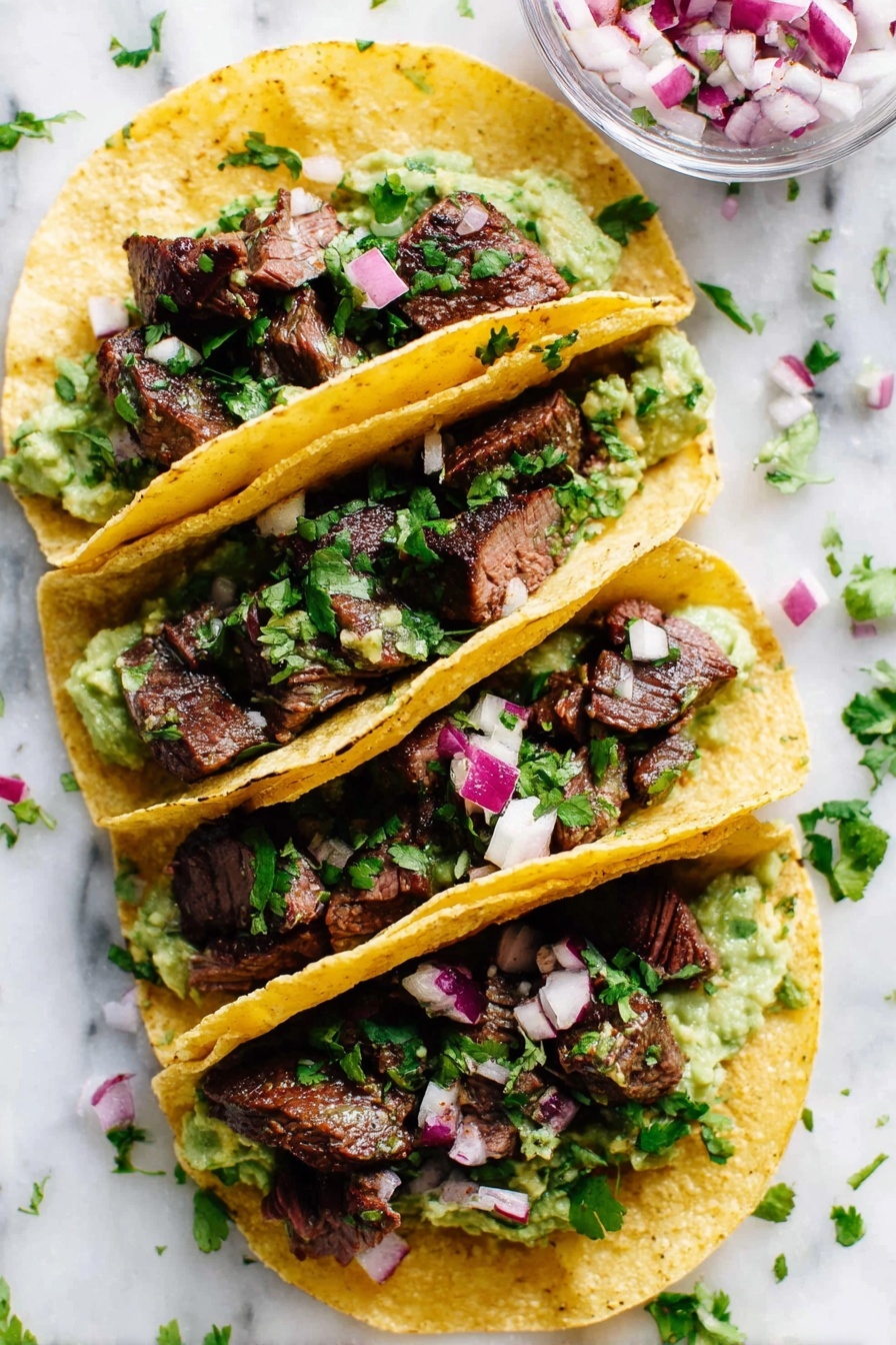 Four yellow corn tortillas are filled and folded in half, each stacked with three layers: a creamy green guacamole base, topped with chunky dark brown pieces of grilled steak, and garnished with small, diced purple and white onions along with fresh green cilantro leaves sprinkled over all. The tacos are placed closely on a white marbled surface, with some onion pieces and cilantro leaves scattered around. A clear glass bowl with diced red onions is partially visible in the upper right corner. The photo taken with an iphone --ar 2:3 --v 7 - Marinated Mojo Steak Tacos, flavorful steak tacos, quick guacamole recipe, citrus marinade steak, easy taco dinner ideas