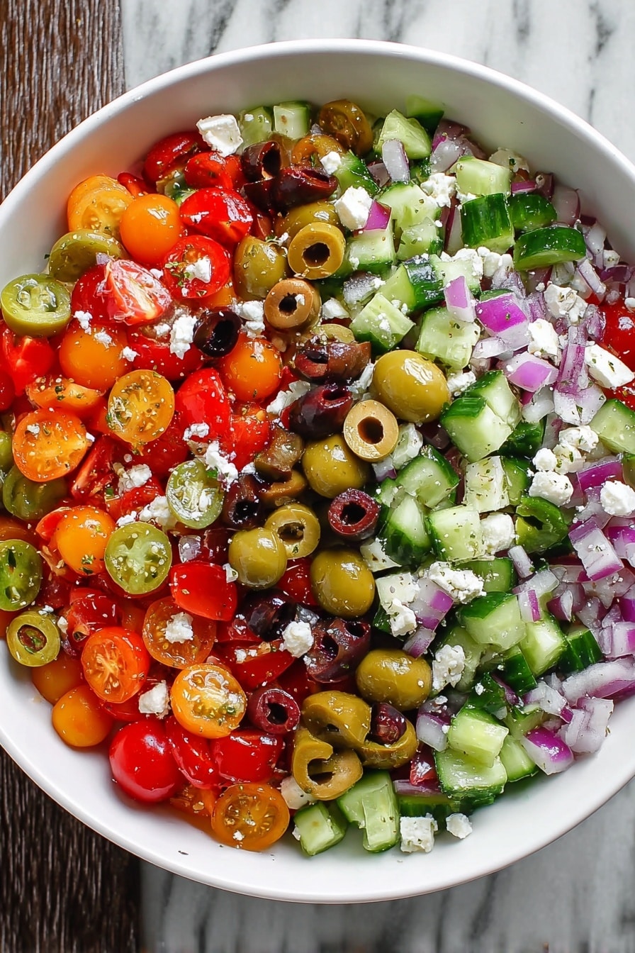 A white bowl filled with a colorful salad showing at least five layers of mixed vegetables and cheese. The bottom layer includes chopped red and orange cherry tomatoes that are halved, with bright green cucumber chunks scattered around. On top of that are slices of black and green olives, revealing their hollow centers. Small cubes of red onion add a purple touch scattered evenly throughout. The salad is sprinkled with small white crumbles of cheese, creating a soft texture contrast among the fresh vegetables on the white marbled surface. Photo taken with an iphone --ar 2:3 --v 7 - Greek Salad with Feta and Olives, Greek salad recipe, Mediterranean salad with feta, Easy Greek salad, healthy Greek salad ideas