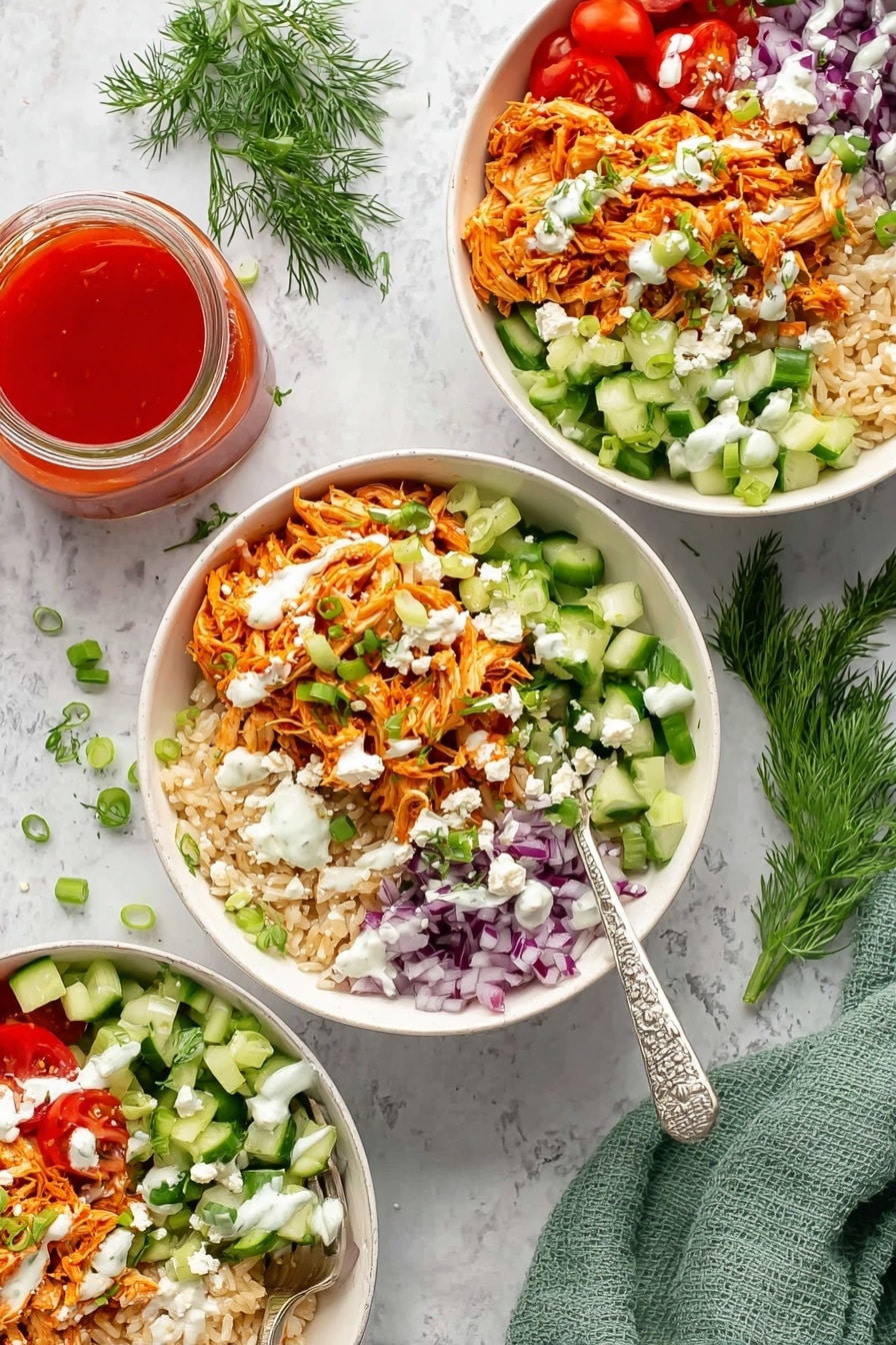 The image shows three white bowls filled with layered food on a white marbled surface. Each bowl has a bottom layer of light brown rice, topped with shredded orange chicken on one side. Around the chicken, there are sections of bright green chopped cucumber, shredded orange carrots, halved red cherry tomatoes, and finely chopped purple onions. White creamy dressing is drizzled over the top, along with small white crumbles of cheese and green sliced scallions scattered across the layers. A silver fork with a white and black handle rests inside each bowl. Nearby, there is a small glass jar filled with bright red sauce and a green cloth napkin, along with sprigs of fresh dill for decoration. Photo taken with an iphone --ar 2:3 --v 7 - Buffalo Chicken Rice Bowls, buffalo chicken meal, easy rice bowl recipes, healthy chicken dinner, quick protein-packed meals