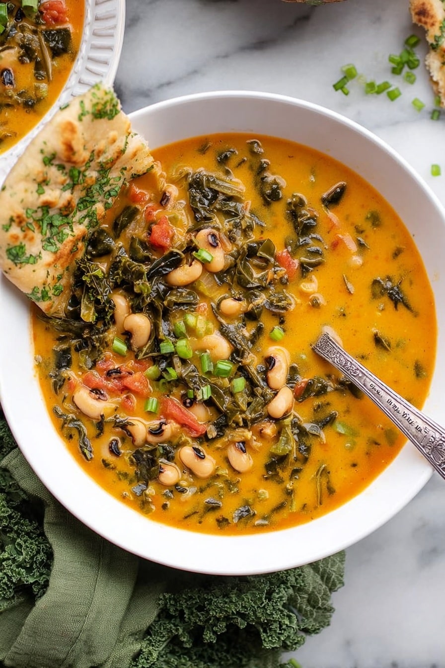 A white bowl filled with a thick orange-yellow soup containing dark green leafy vegetables, black-eyed peas, and small chunks of red tomato. The soup has a creamy texture and is garnished with small green onion pieces and herbs on top. A piece of flatbread with green herbs is resting on the bowl's edge. A silver spoon with an engraved handle is partly dipped into the soup. The bowl is placed on a green cloth on a white marbled surface. Photo taken with an iphone --ar 2:3 --v 7 - Spicy Black-Eyed Peas and Kale Soup, hearty vegetarian soup, healthy black-eyed pea recipes, vegan comforting soups, easy spicy pea and kale soup
